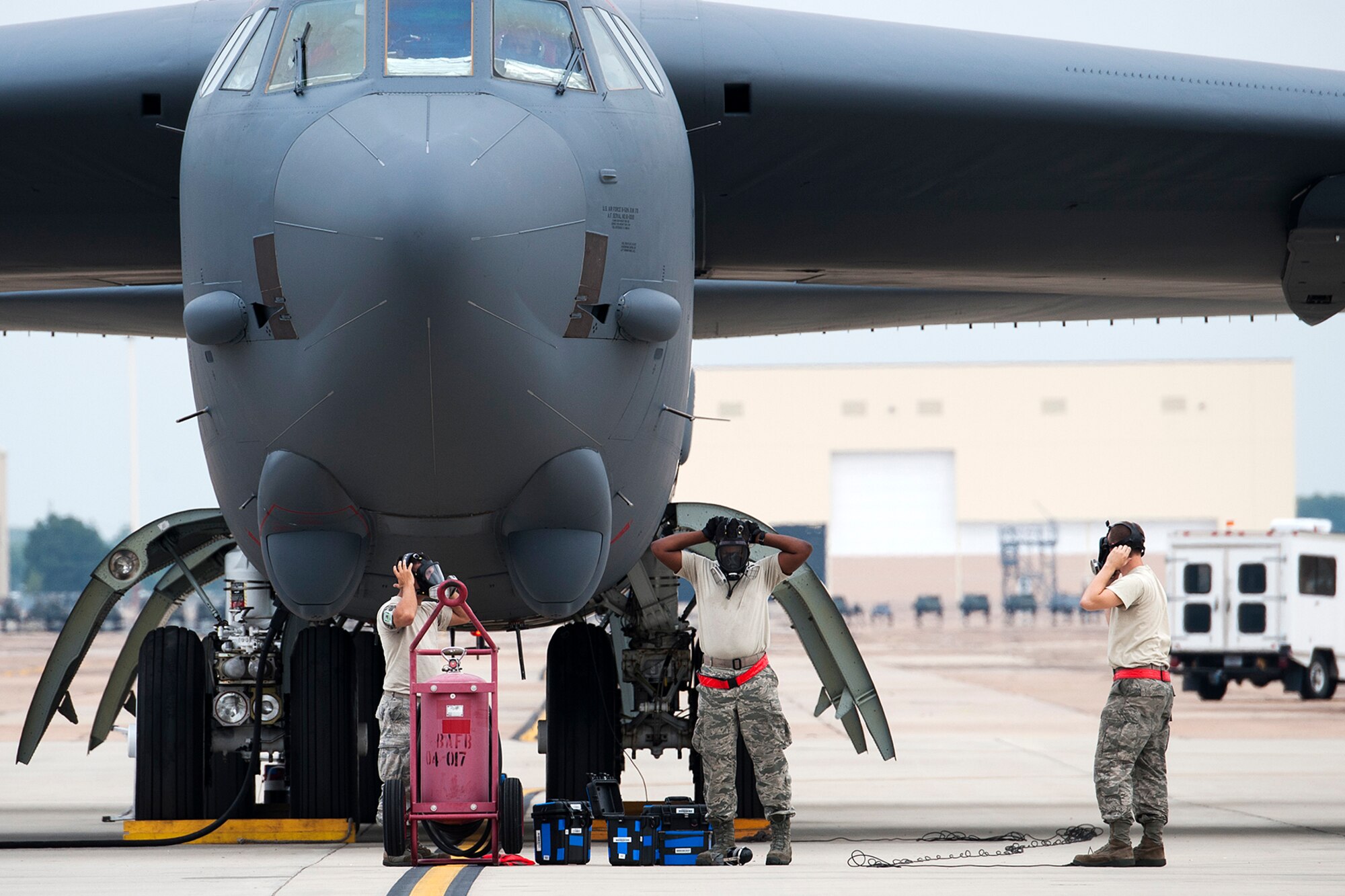 Crew chiefs assigned to the 2nd Aircraft Maintenance Squadron, put on respirators prior to the "cart-start" of a B-52H Stratofortress, Sept. 18, 2014, Barksdale Air Force Base, La. Impulse carts are installed in the engines, giving them a jumpstart on ignition, which lessens the engine start time, but produces a large plume of smoke. (U.S. Air Force photo by Master Sgt. Greg Steele/Released)