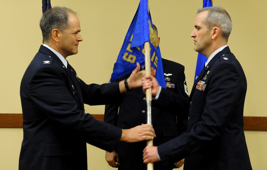 Col. Douglas Drakeley, 655th Intelligence, Surveillance and Reconnaissance Group commander, left, hands the 28th Intelligence Squadron guideon to its newly installed commander, Lt. Col. Joseph Marcinek, during the squadron's activation and assumption of command ceremony Sept. 24, 2014 at Hurlburt Field, Fla.  The 919th Special Operations Wing will provide continuous support to the Hurlburt-based Air Force Reserve unit in the areas of financial management, military pay and force support.  (U.S. Air Force photo/Senior Airman Christopher Callaway) 