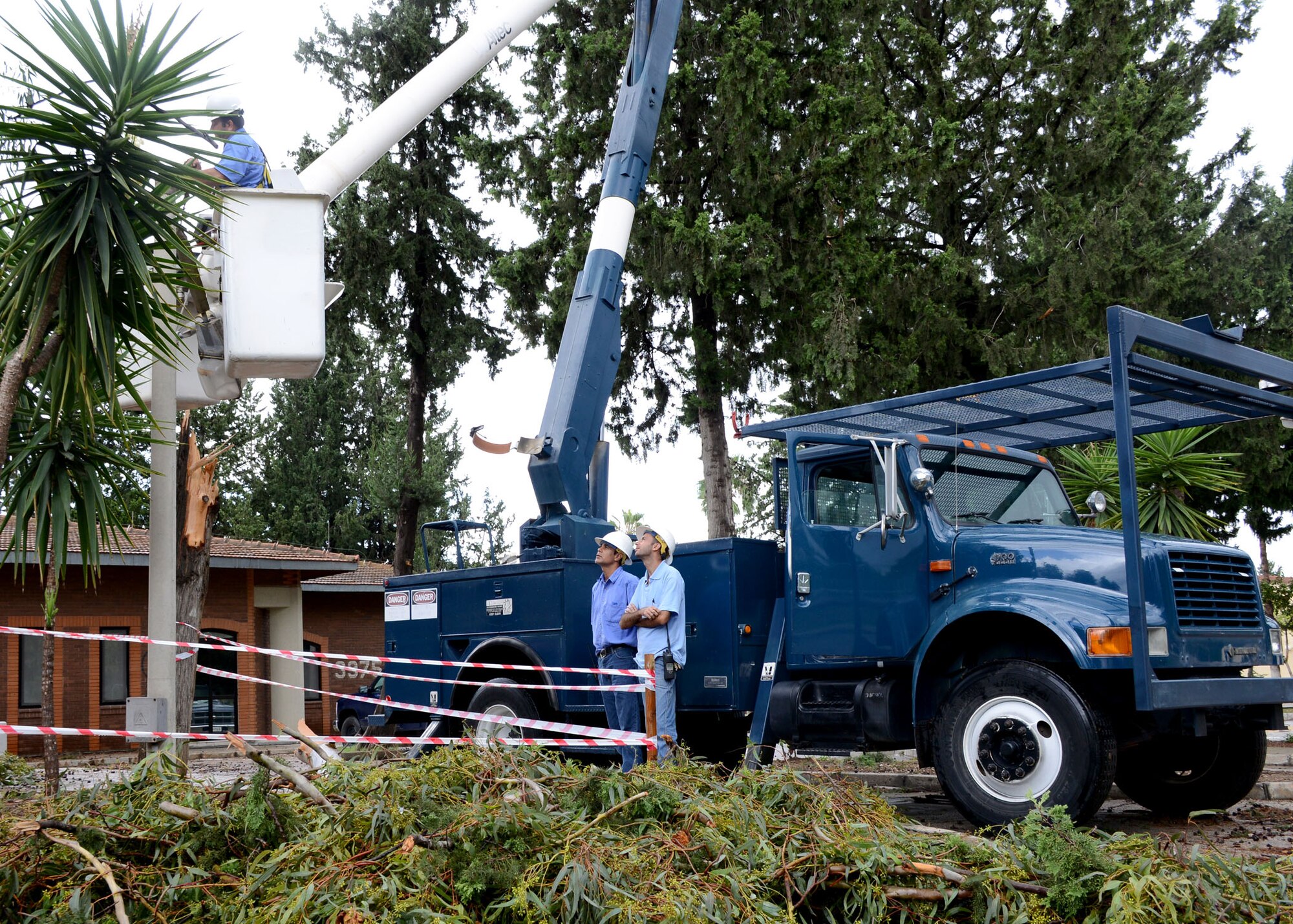 A crew with the 39th Civil Engineer Squadron, secures and repair a light post Sept. 28, 2014, Incirlik Air Base, Turkey. A storm came through Incirlik AB on the evening of Sept. 27, brining strong winds up to 72 miles per hour, resulting in dozens of fallen trees and structural damage. (U.S. Air Force photo by Staff Sgt. Veronica Pierce/Released) 