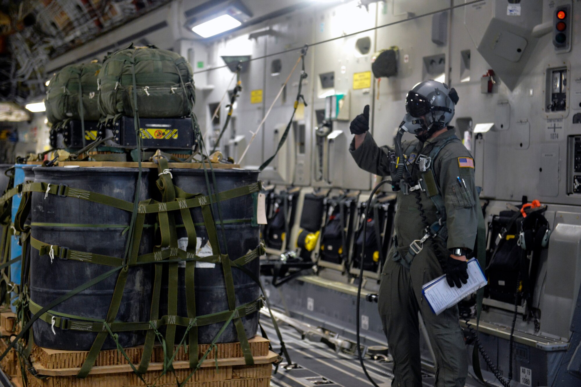 Tech. Sgt. Doug Hollingsworth, 8th Airlift Squadron loadmaster, lets his crew members know that he is ready to drop the next joint precision airdrop system September 25, 2014, during a training mission near Joint Base Lewis-McChord, Wash. In order to drop a JPADS, the aircraft must make two passes over the drop zone, first dropping the dropsonde ultra-high frequency receiver and then the load itself. (U.S. Air Force photo/Staff Sgt. Russ Jackson)