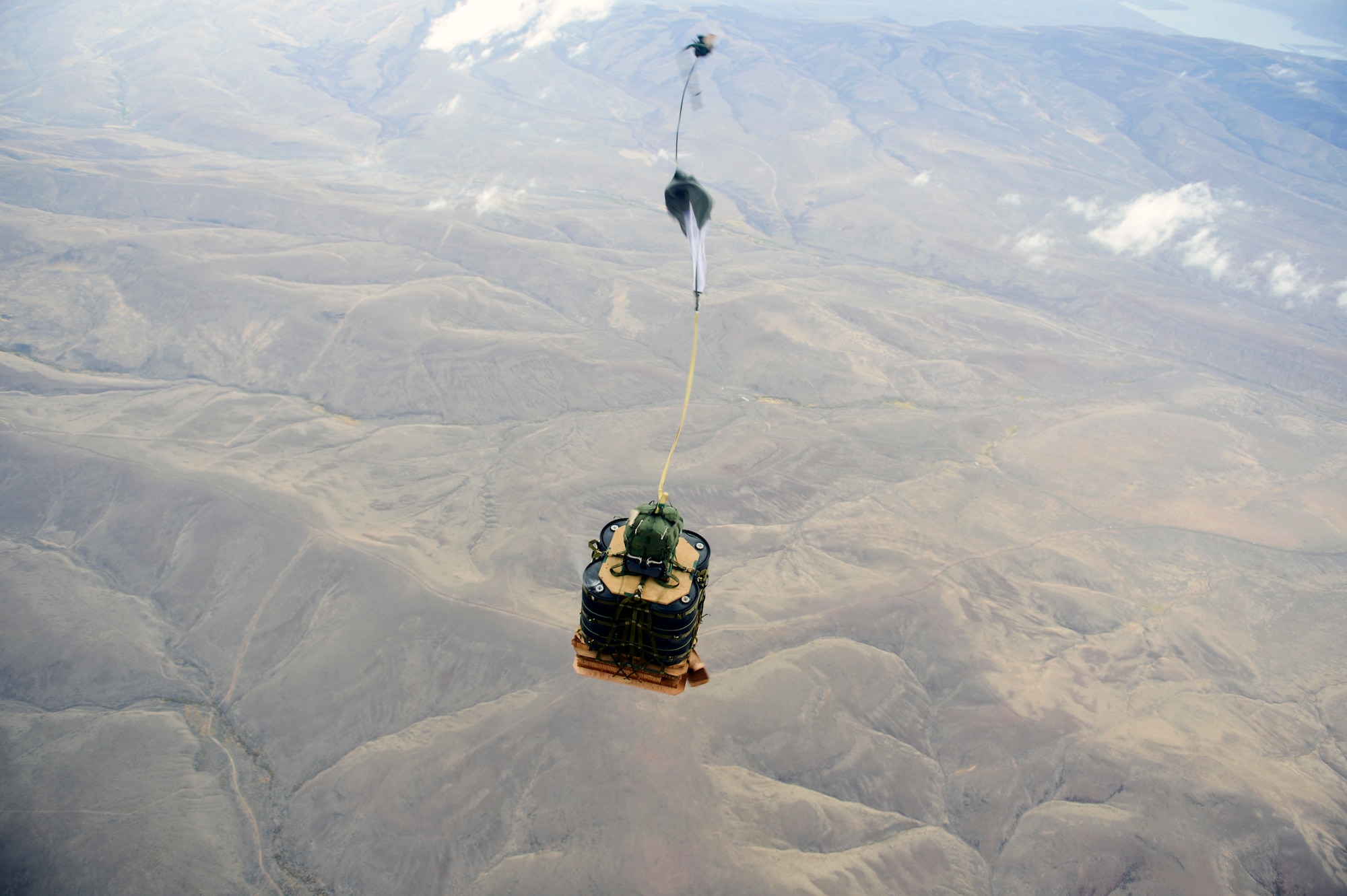 Cargo utilizing a joint precision airdrop system falls from a C-17 Globemaster III aircraft September 25, 2014, during a training mission near Joint Base Lewis-McChord, Wash. JPADS is a unique airdrop capability that allows for cargo delivery from altitudes beyond the range of many ground threats and often offset from the intended point of impact and places the airdropped cargo within meters of the planned point of impact. (U.S. Air Force photo/Staff Sgt. Russ Jackson)