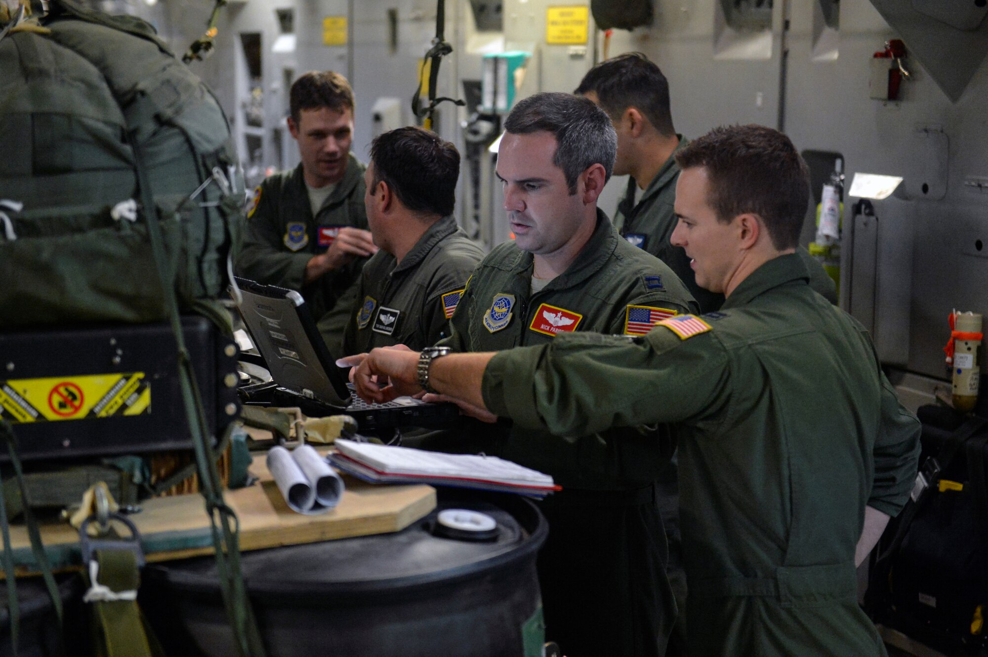 Capt. Nick Parise (center), and Capt. Chris Mahan (right), 10th Airlift Squadron pilots, link their mission planning system laptop with the computers in the joint precision airdrop systems September 25, 2014, on their C-17 Globemaster III aircraft during a training mission at Joint Base Lewis-McChord, Wash. The JPADS mission plan included all software loaded on an MPS laptop computer and aircraft mission support equipment required to execute the precision airdrop. (U.S. Air Force photo/Staff Sgt. Russ Jackson)