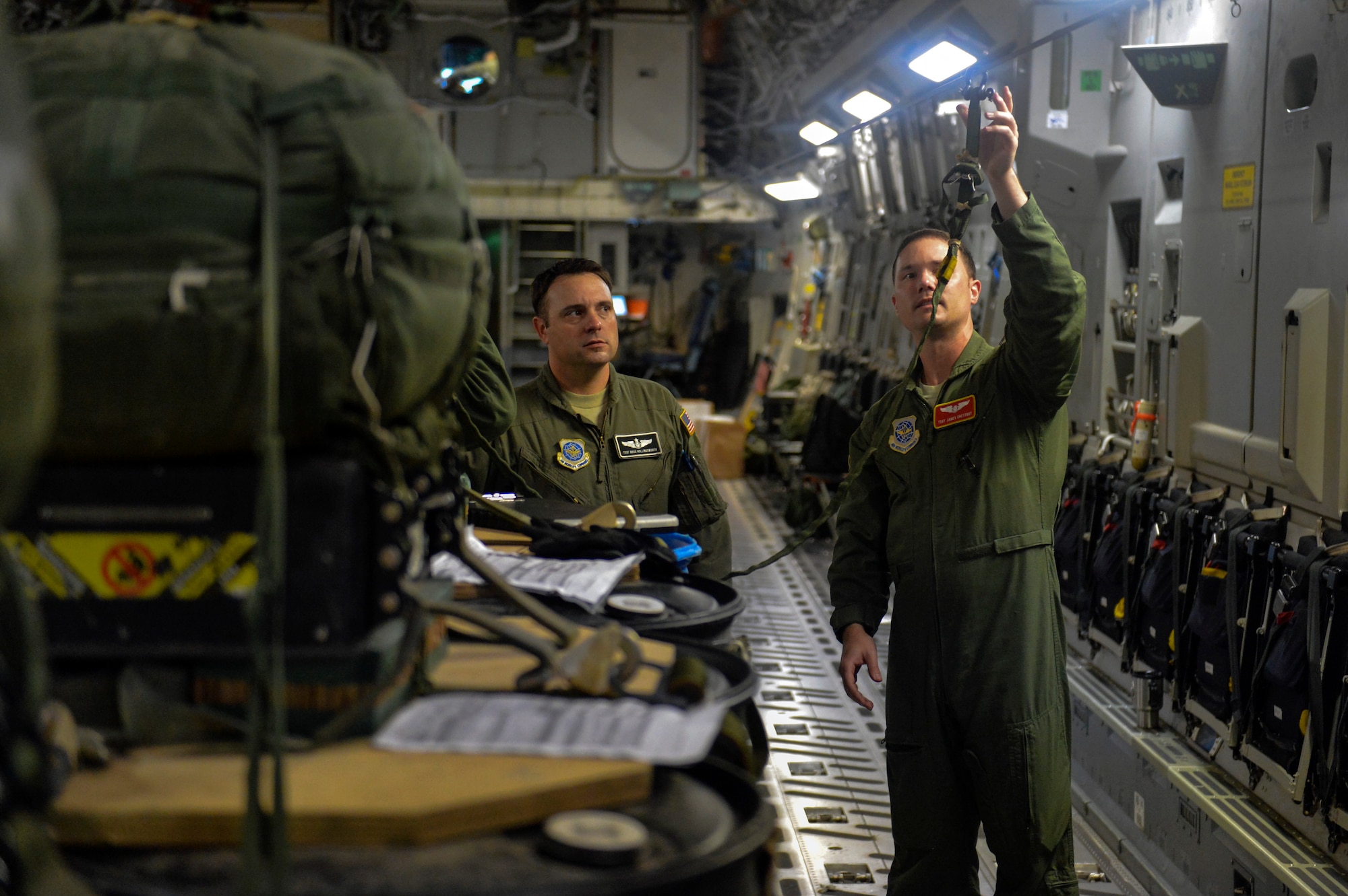 Tech. Sgt. James Chestnut (right), 10th Airlift Squadron loadmaster, shows Tech. Sgt. Doug Hollingsworth, 8th AS loadmaster, his rigging of the release-away static line for a joint precision airdrop system September 25, 2014, on a C-17 Globemaster III aircraft during a training mission at Joint Base Lewis-McChord, Wash. JPADS allows an aircraft to avoid the threats found in the low-altitude airdrop environment by increasing altitude and providing standoff distances while maintaining precision accuracy. (U.S. Air Force photo/Staff Sgt. Russ Jackson)