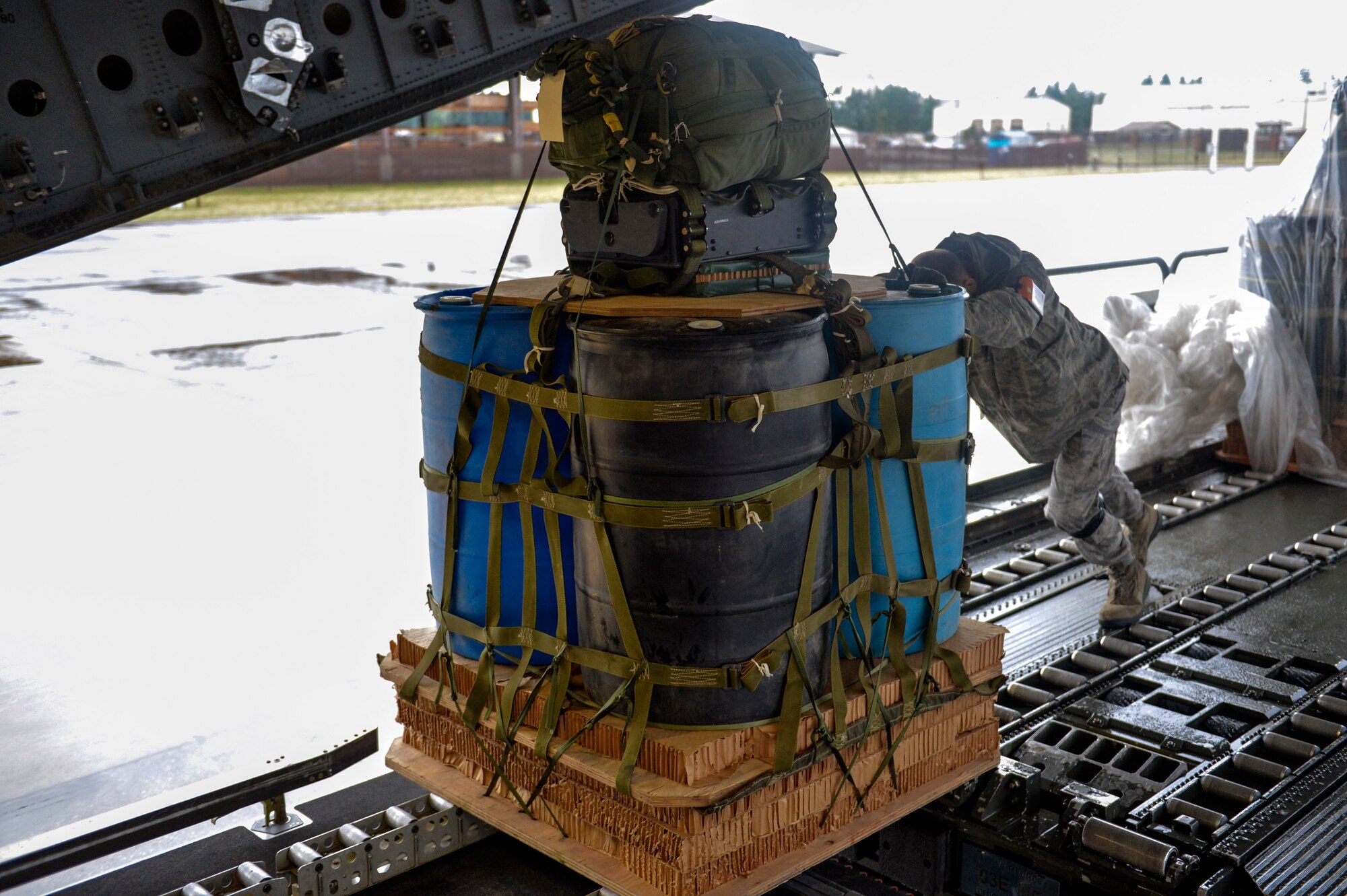Staff Sgt. Ramsey Tesch, 62nd Aerial Port Squadron air terminal operations center information controller, pushes a joint precision airdrop system bundle onto a C-17 Globemaster III aircraft September 25, 2014, during a training mission at Joint Base Lewis-McChord, Wash. Airmen from the 62nd APS loaded the JPADS onto a 60K tunner loader and brought them out to the C-17 in order to turn them over to the aircrew. (U.S. Air Force photo/Staff Sgt. Russ Jackson)