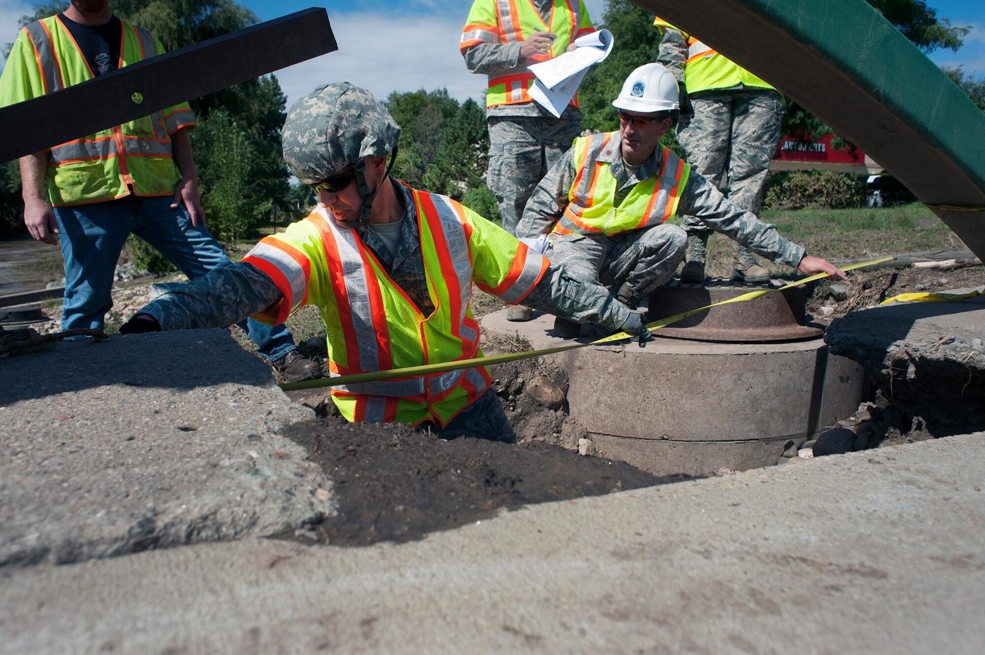 Members of the Colorado Air National Guard's 240th Civil Engineering Flight use a tape measure to measure the damage to a bridge affected by floodwaters in Loveland, Colorado, Sept. 19, 2013. 
