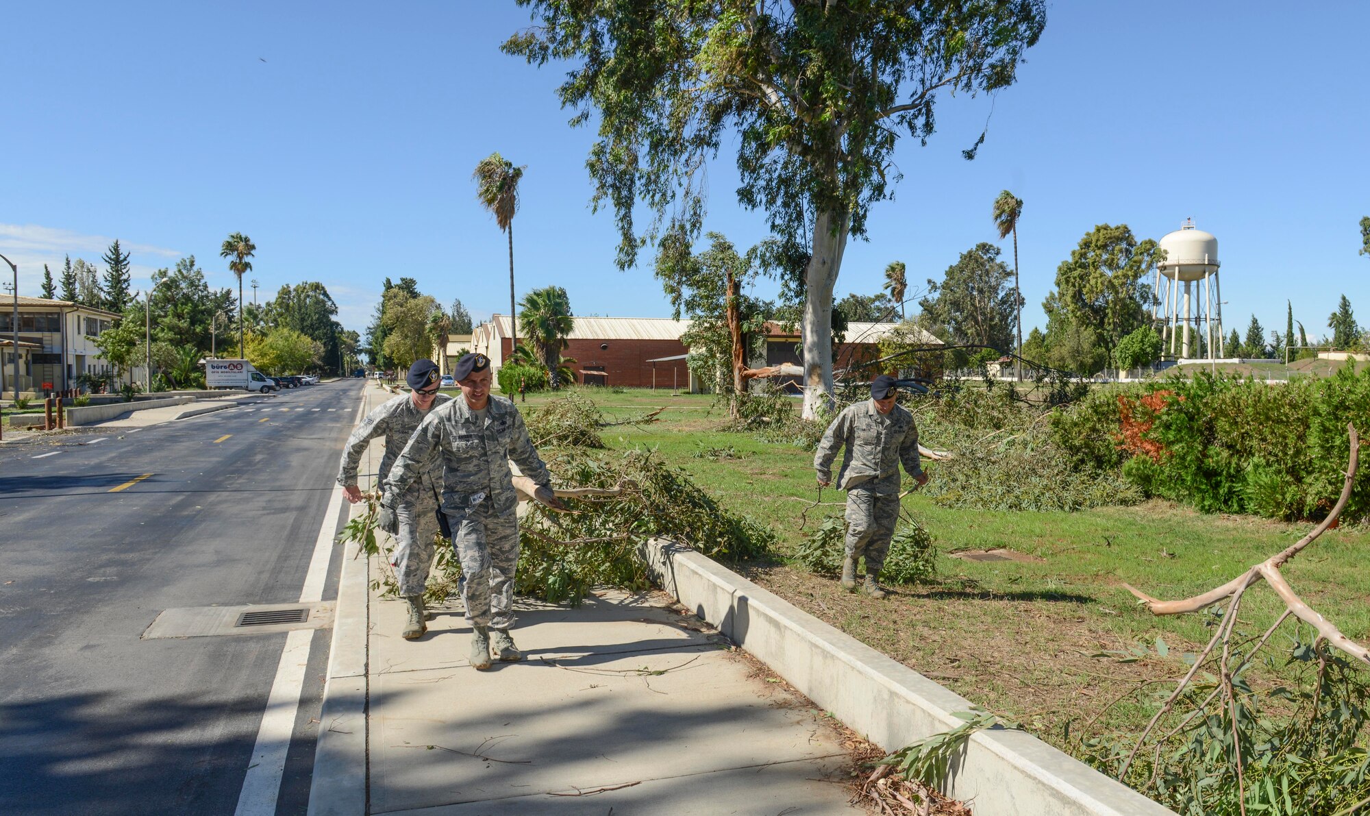 Airmen from the 39th Security Forces Squadron pick up tree branches after a storm Sept. 29, 2014, Incirlik Air Base Turkey.  The storm brought severe winds that reached an estimated 72 mph. (U.S. Air Force photo by Staff Sgt. Eboni Reams/Released) 