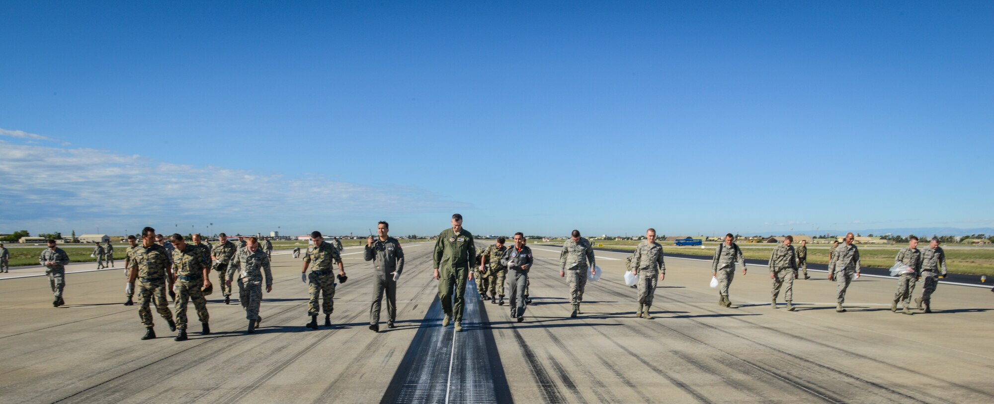 Turkish and U.S. Airmen conduct a foreign object debris walk on the runway after a storm Sept. 29, 2014, Incirlik Air Base, Turkey.  More than 350 members combined participated in the FOD walk and collected a total of 12 pounds of debris on the runway, ramps and taxiways. (U.S. Air Force photo by Staff Sgt. Eboni Reams/Released) 