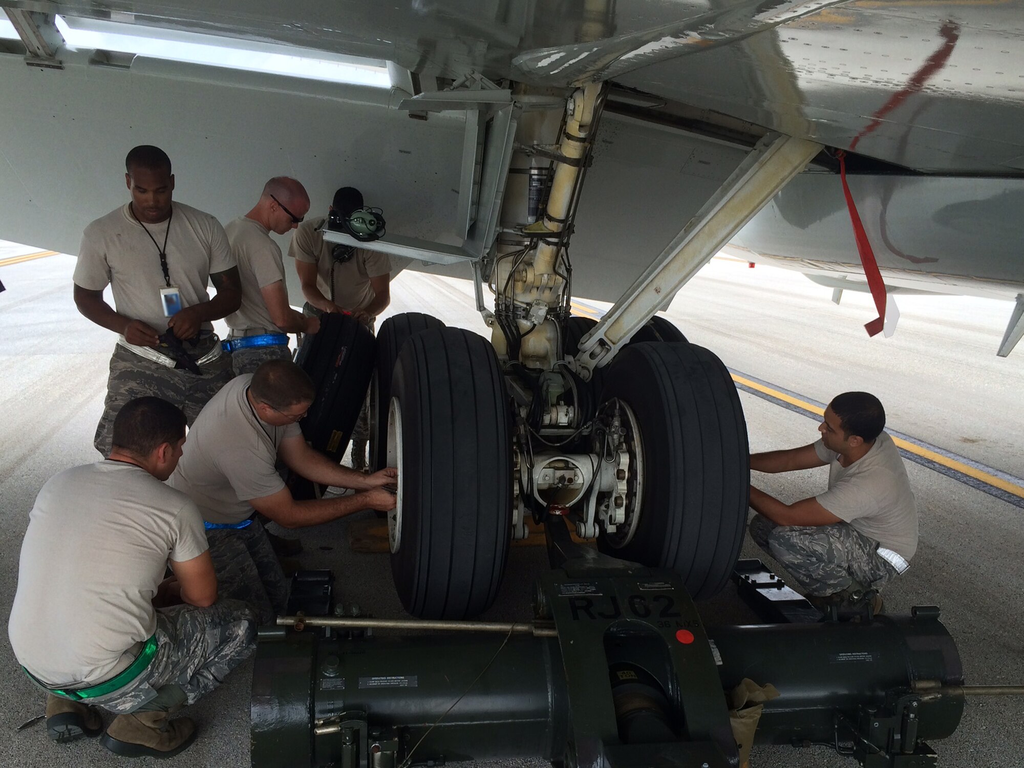 Members of the 718th Aircraft Maintenance Squadron from Kadena Air Base, Japan, perform a tire change on an E-3 Sentry Airborne Warning and Control System aircraft during Valiant Shield on Andersen Air Base, Guam, Sept. 19, 2014. Valiant Shield is a U.S.-only exercise integrating an estimated 18,000 Navy, Air Force, Army and Marine Corps personnel, more than 200 aircraft and 19 ships, offering real-world joint operational experience to develop capabilities that provide a full range of options to defend U.S. interests and those of its allies and partners. (U.S. Air Force photo by Lt. Col. Frederick Coleman/Released)