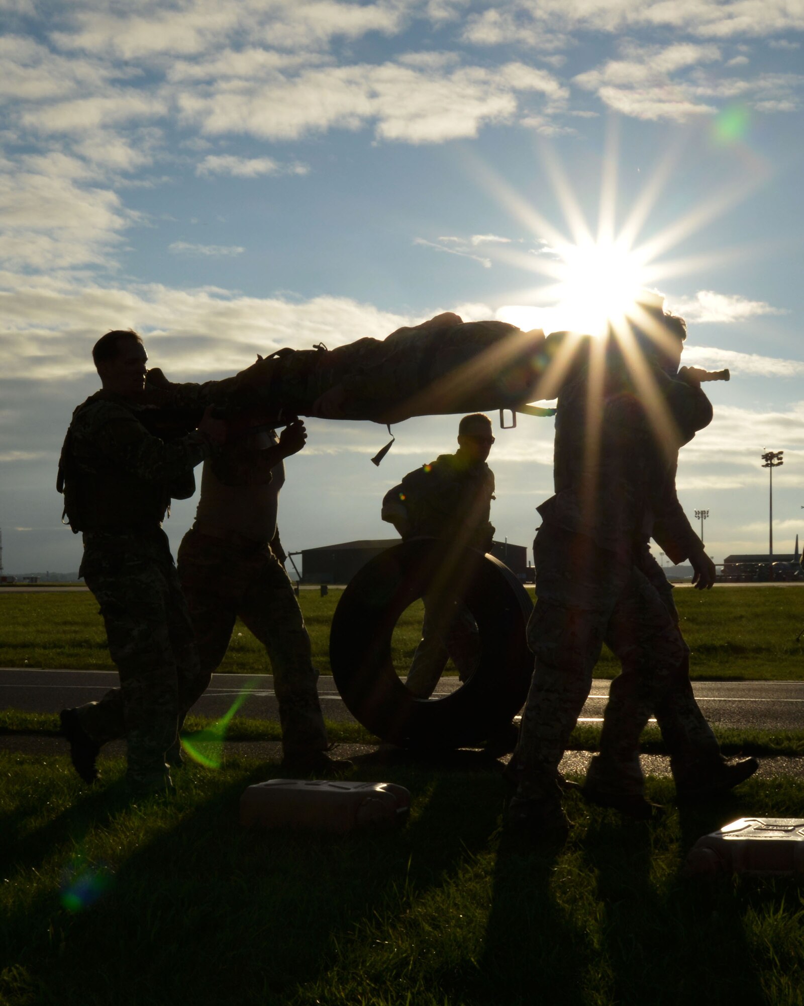 A team carries an “injured” teammate, jerry cans of water and tires to the next station during the Monster Mash Sept. 26, 2014, on RAF Mildenhall, England. The Monster Mash consisted of various events such as carrying an inflatable boat, marching with a 40-pound rucksack and a blind weapons assembly. A Monster Mash is a long-standing special tactics tradition which combines events designed to test strength, stamina and problem solving skills. (U.S. Air Force photo/Tech. Sgt. Stacia Zachary/Released)
