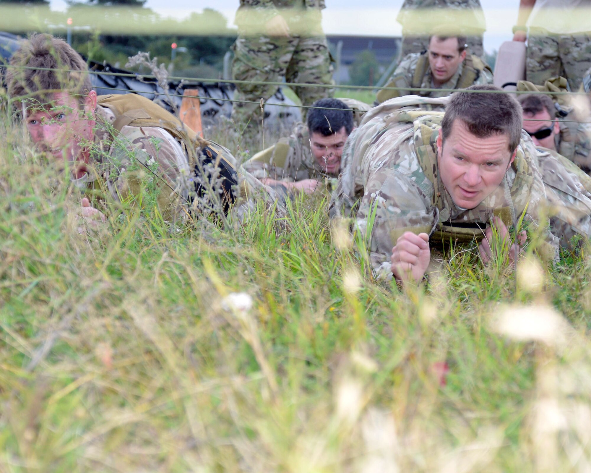U.S. Air Force Master Sgt. Tim Garlock, right, 321st Special Tactics Squadron combat controller, and U.S. Air Force Staff Sgt. Alan Abraham, 321st STS combat controller, navigate a high- and low-crawl station during the Monster Mash Sept. 26, 2014, on RAF Mildenhall, England. The Monster Mash consisted of various events such as carrying an inflatable boat, marching with a 40-pound rucksack and a blind weapons assembly. A Monster Mash is a long-standing special tactics tradition which combines events designed to test strength, stamina and problem solving skills. (U.S. Air Force photo/Tech. Sgt. Stacia Zachary/Released)