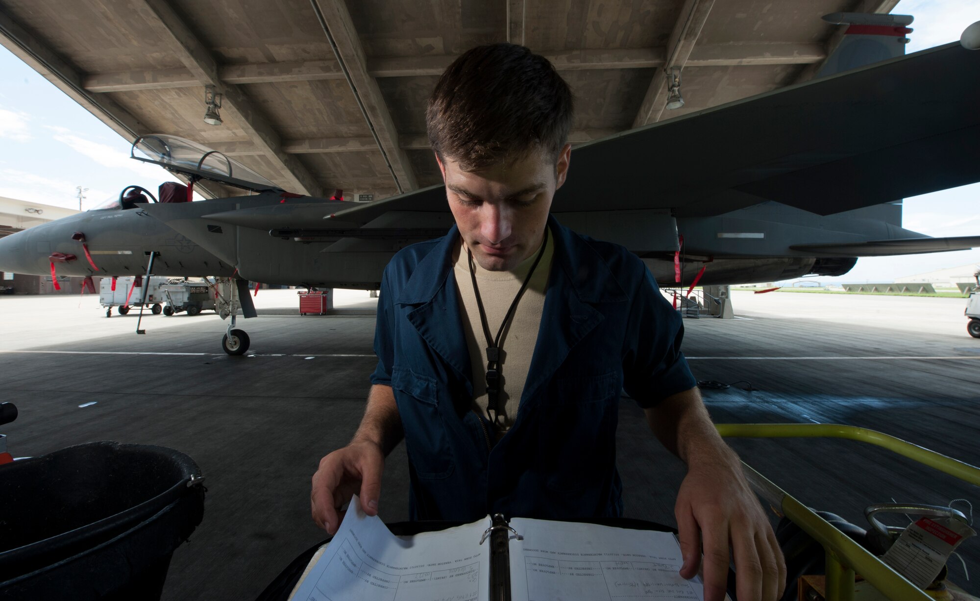 U.S. Air Force Senior Airman Dillon Gross, 67th Aircraft Maintenance Unit F-15 Eagle crew chief, reviews technical orders before beginning maintenance on a jet on Kadena Air Base, Japan, Sept. 16, 2014. Sept. 29, 2014, marks the 35th anniversary of the F-15Cs arrival to Kadena. With a perfect record of more than 100 confirmed kills and no combat losses in operations and contingencies ranging from Turkey and Bosnia to Iraq and Afghanistan, the Eagle has proven itself time and again. (U.S. Air Force photo by Senior Airman Maeson L. Elleman/Released)