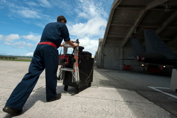 U.S. Air Force Senior Airman Dillon Gross, 67th Aircraft Maintenance Unit F-15 Eagle crew chief, pushes atool box toward an F-15C for maintenance on Kadena Air Base, Japan, Sept. 16, 2014. Sept. 29, 2014, marks the 35th anniversary of the F-15Cs arrival to Kadena. While most people don't maintain a personal vehicle for more than 10 years, the Air Force maintainers and operators here have ensured the safe operation of the F-15C and D models stationed at Kadena for 35 years with countless, thorough inspections and repairs. (U.S. Air Force photo by Senior Airman Maeson L. Elleman/Released)