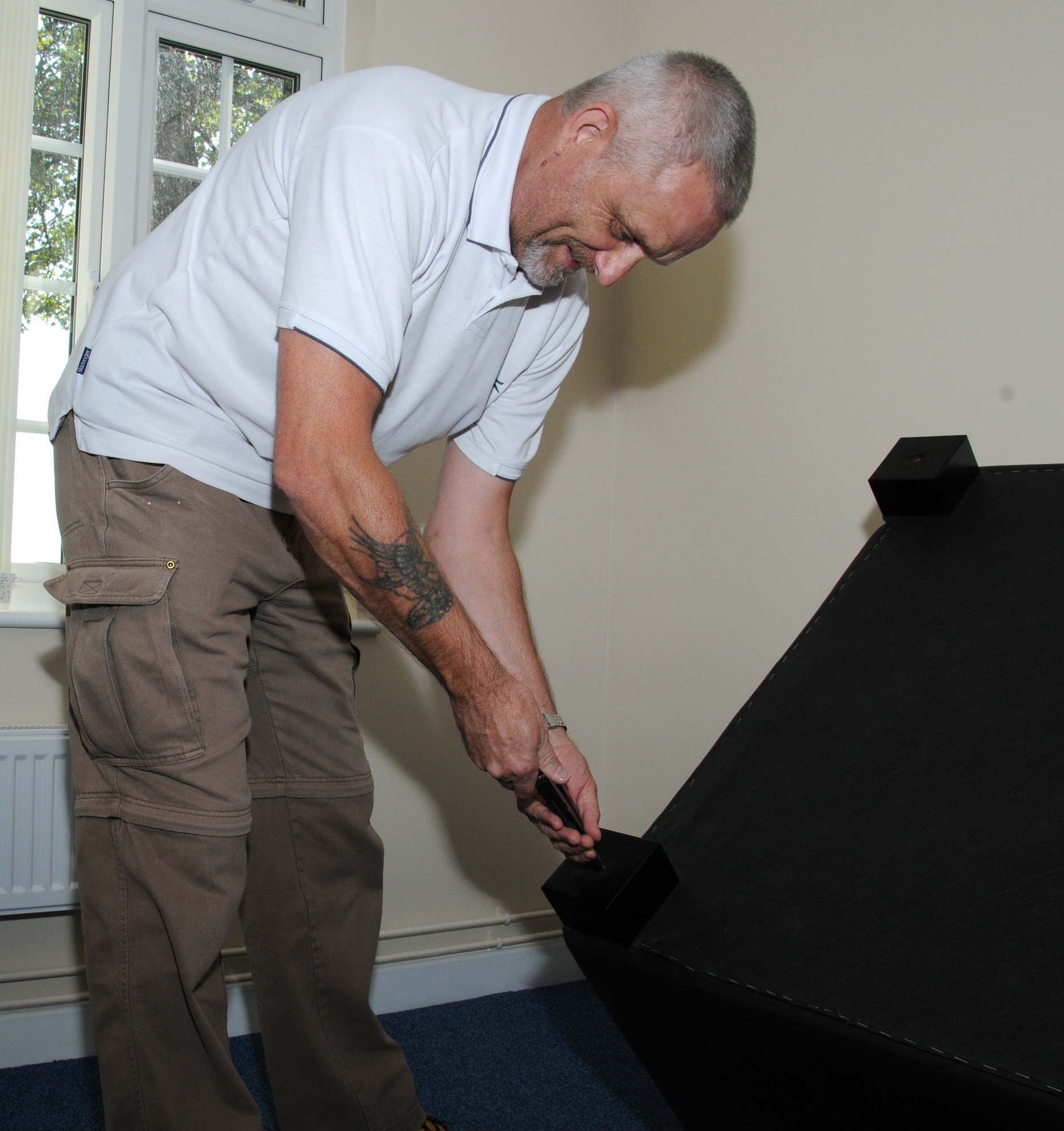 David Priest, 100th Logistics Readiness Squadron vehicle operator from Skegness, England, puts a chair together in the driver lounge following a building move Sept. 8, 2014, on RAF Mildenhall, England. The cargo movement and vehicle operations sections have joined together in Bldg. 582. (U.S. Air Force photo/Gina Randall/Released)