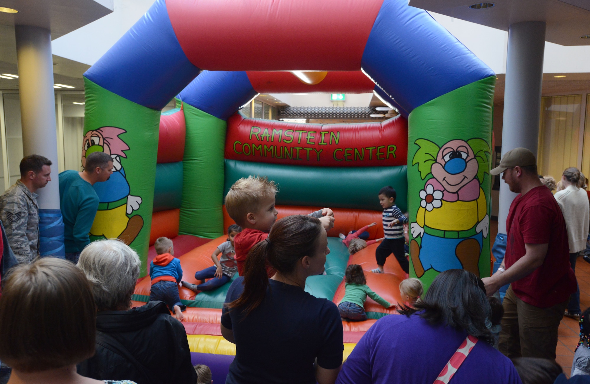 Parents watch as their children play in a bounce house during the Elmo and Cookie Monster Family Night at Ramstein Air Base, Germany, Sept. 22, 2014. The Ramstein Community Center hosts monthly family nights to give parents an opportunity to have a fun filled night with their children away from home. (U.S. Air Force photo/Senior Airman Timothy Moore)