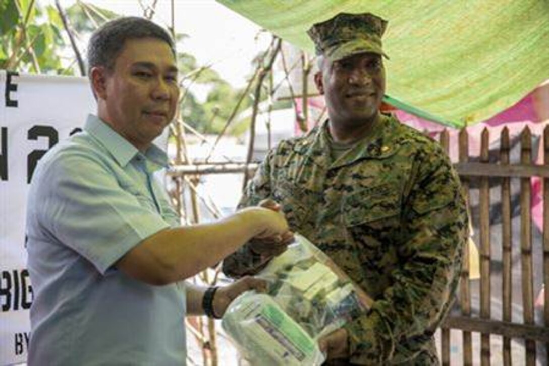 LEGAZPI, Philippines - Vittorio Roces, left, talks with U.S. Marine Majs. Jason Johnson and Grace Janosek about the medical supply donations being made at the Bigaa Health Center May 5 in Bigaa, Albay province, Philippines. The donations were a part of the humanitarian civil assistance programs being completed during Exercise Balikatan, an annual bilateral training exercise between the Philippine and U.S. forces to strengthen the relationship between the two allied nations. Roces is the acting city mayor of Legazpi, Johnson is deputy commander for the Joint Civil Military Operations Task Force, U.S. armed forces, and Janosek is a civil affairs team leader with civil affairs detachment, G3, III Marine Expeditionary Force. 
