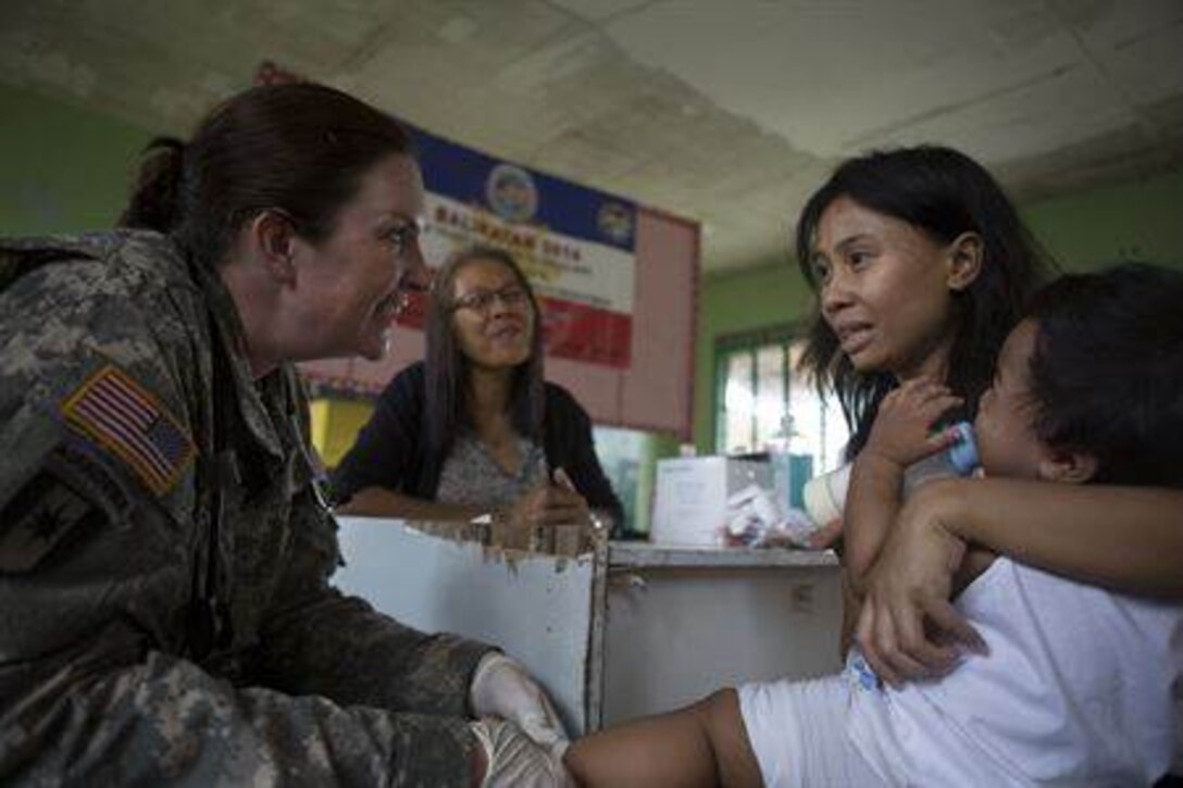 May 12, 2014 TACLOBAN, Philippines - U.S. Army Maj. Kathleen Flocke, family practice doctor, with 97th Civil Affairs Battalion surgeon, Fort Bragg, N.C., examines a patient's wound during a cooperative health engagement during Balikatan 2014 at Fishermans Village Elementary School, Tacloban, Republic of the Philippines, May 10, 2014. The Armed Forces Philippines and U.S. have had a long-standing relationship and welcome the Australian Defence Forces increasing participation in Balikatan.
