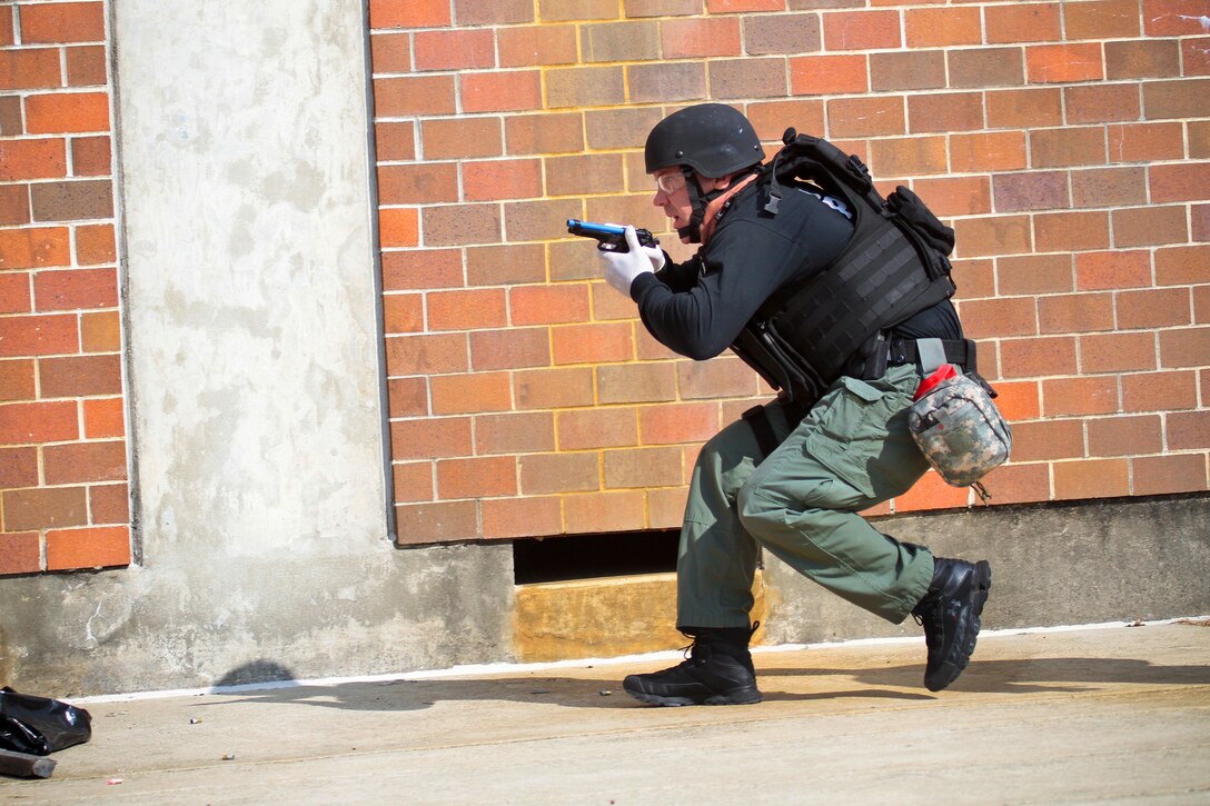 Atlantic City Detective Steve Melchiore runs for cover during tactical combat casualty care training on the Anthony Canale Training Center in Egg Harbor Township, N.J., Sept. 19, 2014. 