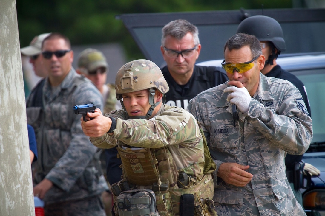 Air Force Staff Sgt. Sean Dixon, foreground, fires simulation rounds ...