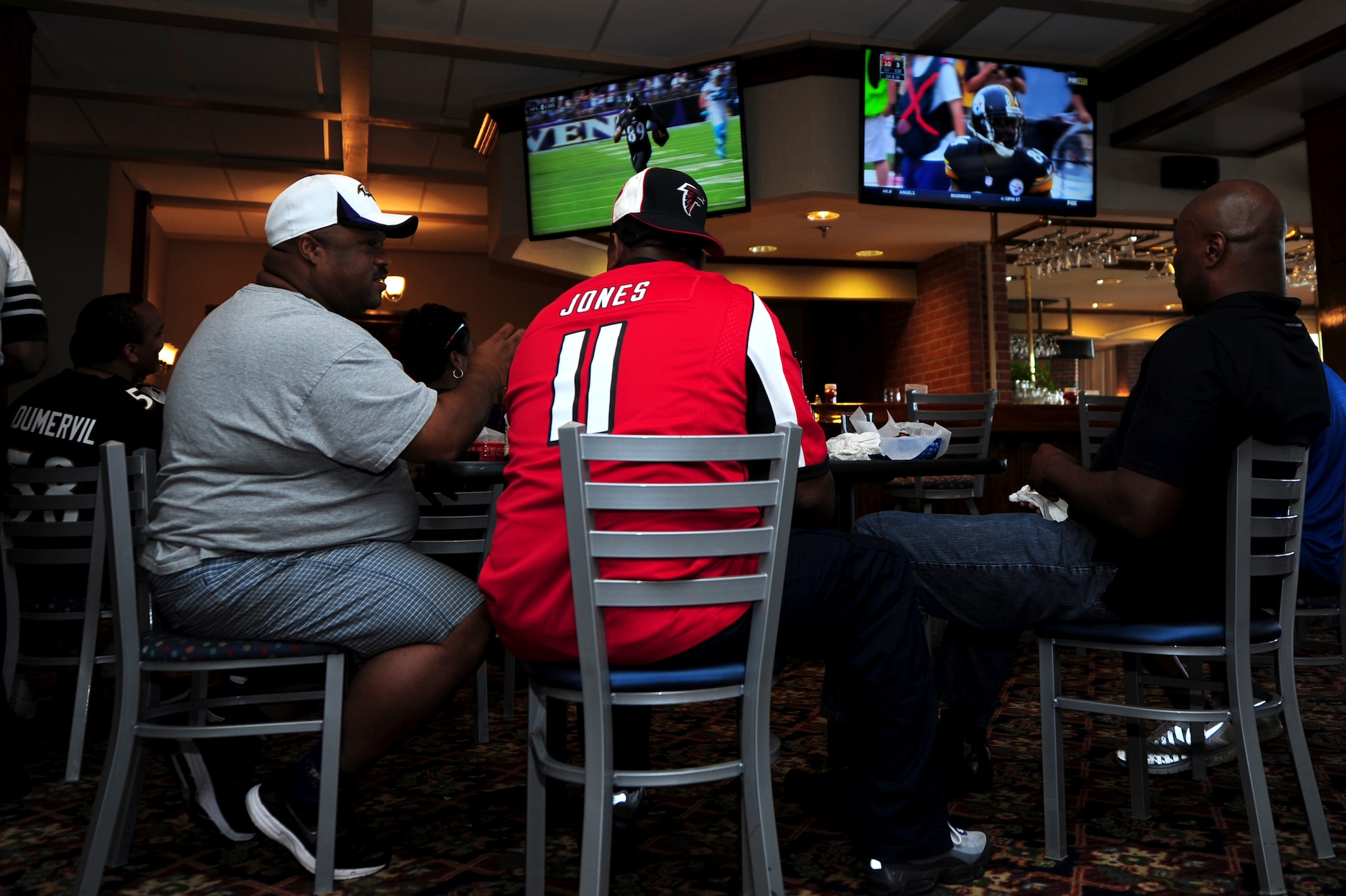 Langley Club patrons watch a football game at Langley Air Force Base, Va. Football Frenzy is just one program offered by Air Force clubs that give patrons the chance to spend time together and cheer on their favorite team. (U.S. Air Force photo/Airman 1st Class Areca T. Wilson) 