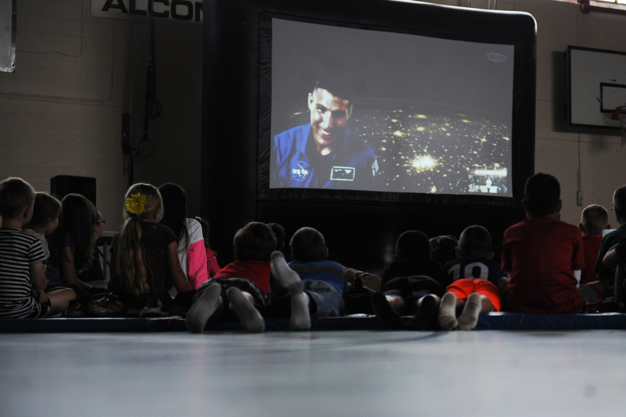 Students listen as NASA astronaut and Air Force Col. Michael Hopkins describes what it is like to see the Earth from space, at night, during a video teleconference at RAF Alconbury, United Kingdom, Sept. 23, 2014. Hopkins described space as an amazing environment which makes the impossible, possible. (U.S. Air Force photo by Staff Sgt. Jarad A. Denton)