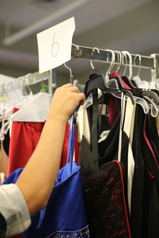 Military wives look through racks of dresses of all colors and sizes at Marine Corps Air Station Cherry Point N.C., Sept. 26, 2014, looking for their perfect fit for the upcoming Marine Corps Birthday Ball during Operation Ball Gown 2014.