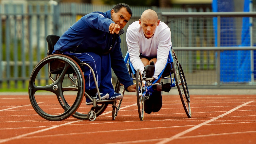 U.S. Marine Corps Staff Sergeant Brad Rich, right, looks toward the finish line during his last day of practice at the Mayesbrooks Training Center, in London, before the start of the 2014 Invictus Games.  The Invictus Games is an opportunity for wounded, ill, and injured service members from around the world to recover and rehabilitate through competing in adaptive sports.