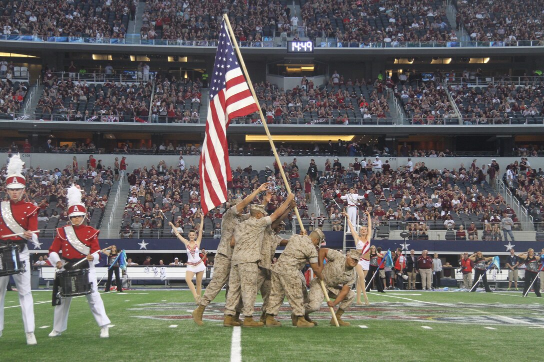 Sgts. Joseph Gamez, Jesus Cardenas, Timothy Clark, Raymundo Cardona, Otniel Abreu and Petty Officer 1st Class Hector Carbajal reenact the raising of the flag on Iwo Jima during the Texas A&M vs. Arkansas football game at AT&T stadium Sept 27. The Arkansas band paid tribute to each branch of service during their segment of the halftime show. Gamez, Clark, Cardona and Abreu are all recruiters with Recruiting Station Dallas. Cardenas is the operations clerk with RS Dallas. Carbajal is a hospital corpsman with 8th Marine Corps District Headquarters. (U.S. Marine Corp photo by Sgt. Daniel E. Valle)
