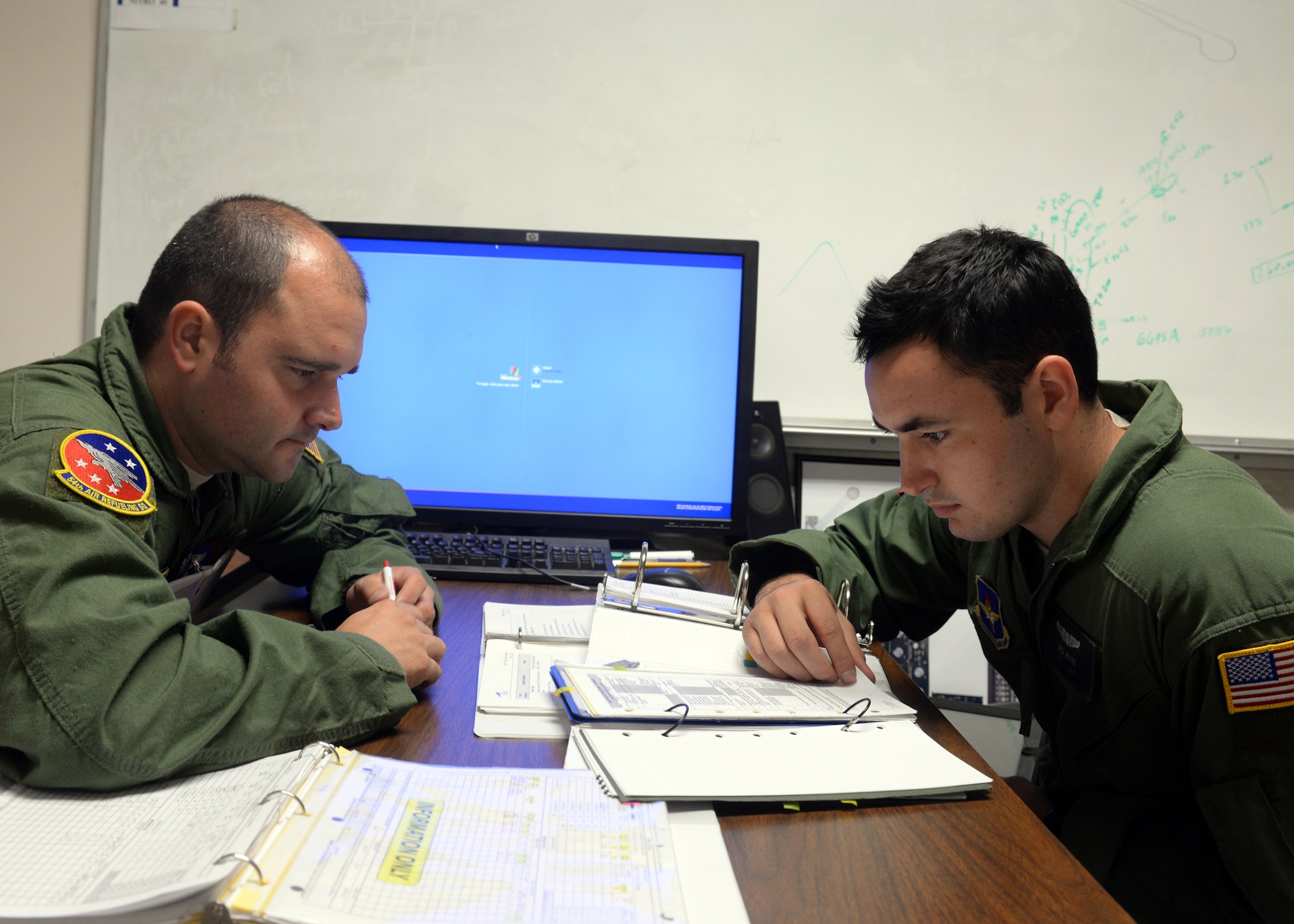 Tech. Sgt. Jon Adams, left, performs a pre-brief with Airman 1st Class Greg Adams Sept. 22, 2014, at the KC-135 aircrew training center on Altus Air Force Base, Okla. Boom operators are aerial refueling specialists who conduct the offloading of fuel to U.S. Air Force and partner aircraft. They also deal with passengers, cargo, aeromedical evacuation missions and work with pilots to ensure the safe operation of the aircraft. Tech. Sgt. Adams is a 54th Air Refueling Squadron instructor boom operator and Airman 1st Class Adams is a student with the 97th Training Squadron. (U.S. Air Force photo/Senior Airman Franklin R. Ramos)