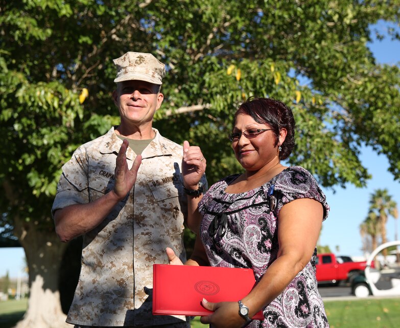 Maj. Gen. Lewis A. Craparotta, Combat Center Commanding General, applauds Josie Nemeth, the Combat Center Adjutant Chief, after she receives the Meritorious Civilian Service Award at Lance Cpl. Torrey L. Gray Field, Sept. 25.