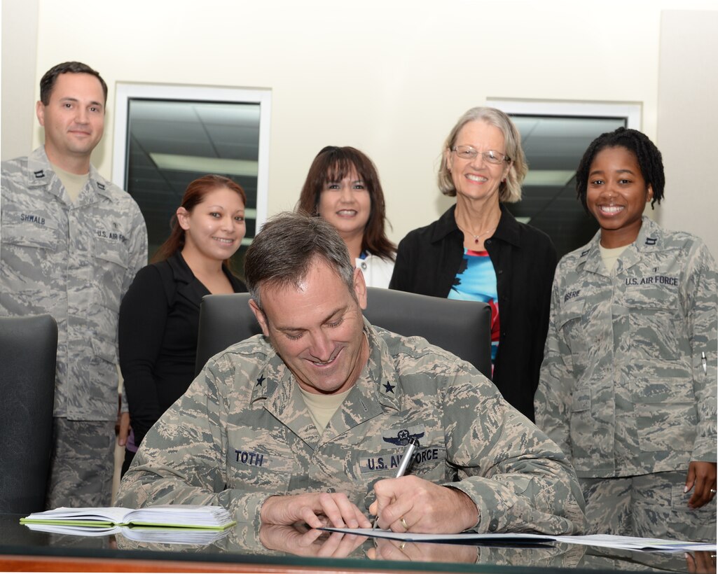 Brig. Gen. Andrew Toth, 36th Wing commander, signs the Domestic Violence Awareness Month proclamation Sept. 30, 2014, on Andersen Air Force Base, Guam. The Family Advocacy Program staff briefed wing leadership on upcoming events to be held throughout the month. (U.S. Air Force photo by Tech. Sgt. Zachary Wilson/Released)