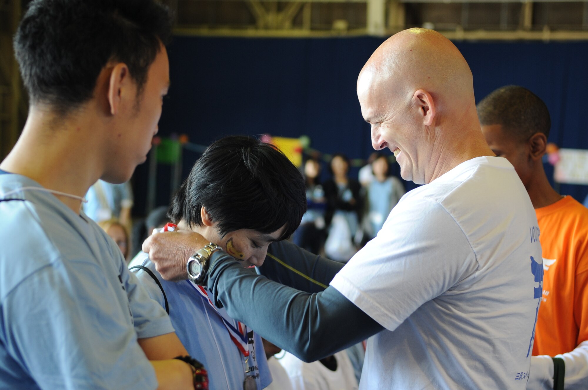 U.S. Air Force Col. Andrew P. Hansen, 35th Fighter Wing vice commander, places a Special Olympics medal around the neck of an athlete during the 28th Annual Special Olympics at Misawa Air Base, Japan, Sept. 27, 2014. Each athlete received a medal from Hansen as a symbol of appreciation for their participation in the Special Olympics. (U.S. Air Force photo by Airman Jordyn Rucker)