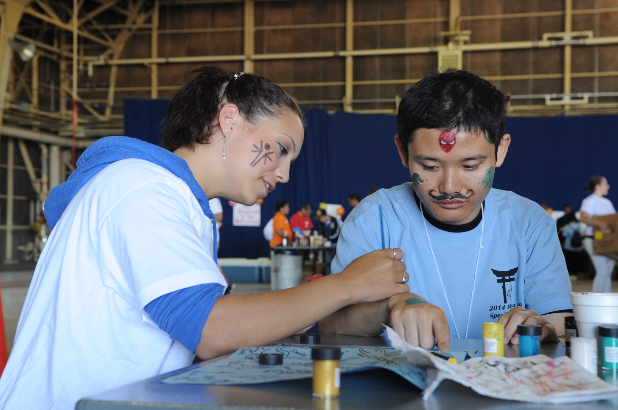 U.S. Air Force Staff Sgt. Elyse Stamey, 35th Fighter Wing NCO in charge of protocol, paints on the hand of a Special Olympic athlete during the 28th Annual Special Olympics at Misawa Air Base, Japan, Sept. 27, 2014. Face painting volunteers spent the day painting characters, animals and other drawings on the hands and faces of athletes. (U.S. Air Force photo by Airman Jordyn Rucker)