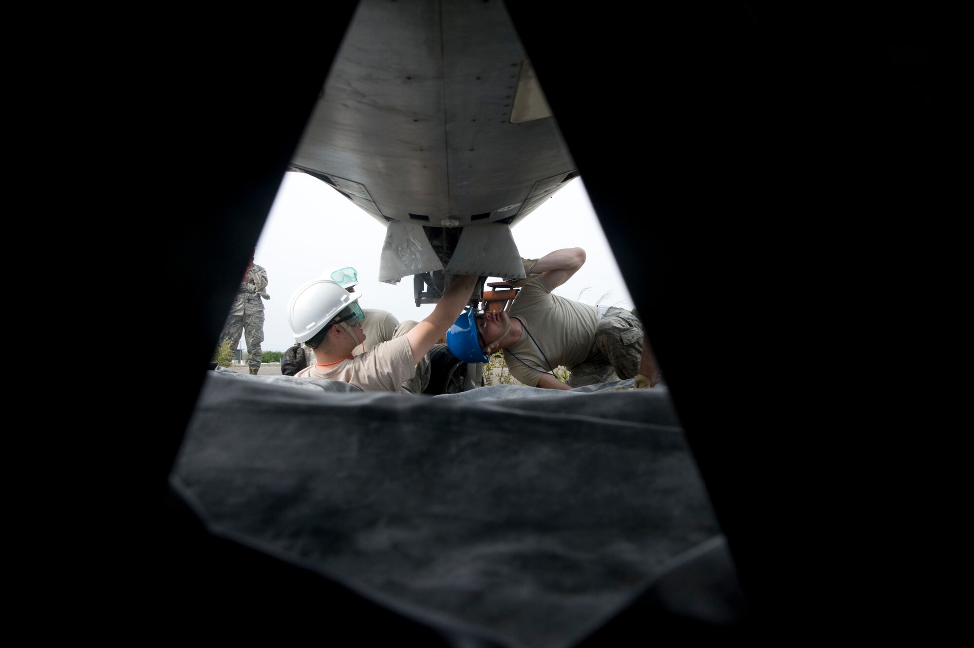 U.S Air Force Staff Sgt. Timothy Amburn and U.S Air Force Staff Sgt. Michael Cooper, 35th Maintenance Squadron crash recovery team members, work on the underside of an aircraft during a crash recovery exercise at Misawa Air Base, Japan, Sept. 23, 2014. The team utilizes airbags to lift the aircraft from the ground. (U.S. Air Force photo by Staff Sgt. Alyssa C. Wallace)