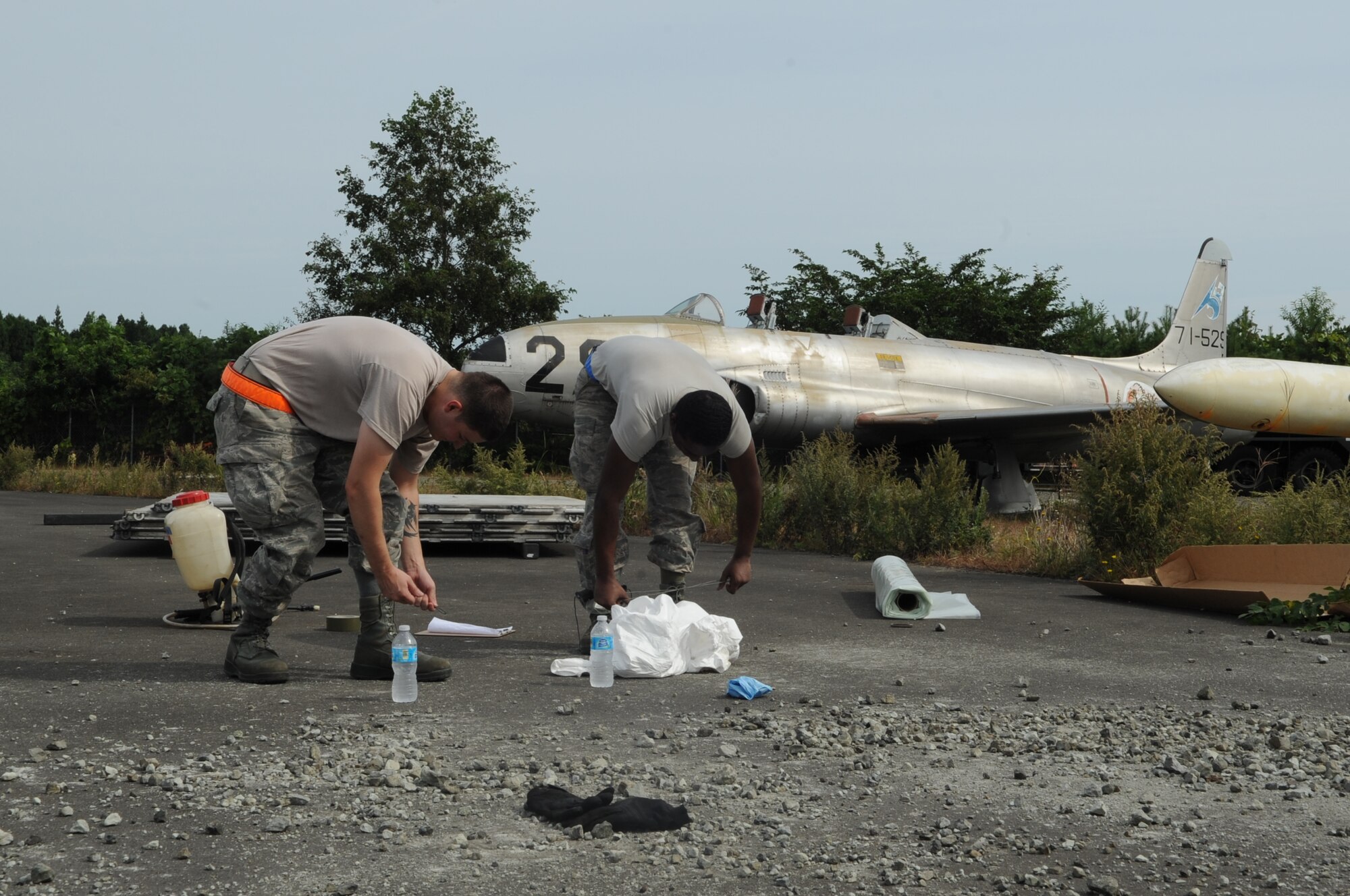 U.S Air Force Staff Sgt. Timothy Amburn and U.S Air Force Airman 1st Class Blake Cyrus, 35th Maintenance Squadron crash recovery team members, remove their gear after conducting an inspection during a crash recovery exercise at Misawa Air Base, Japan, Sept. 23, 2014. In this scenario, the aircraft was impeding the runway and the mission was to move it in order to enable the runway to be reopened. (U.S. Air Force photo by Airman Jordyn Rucker)