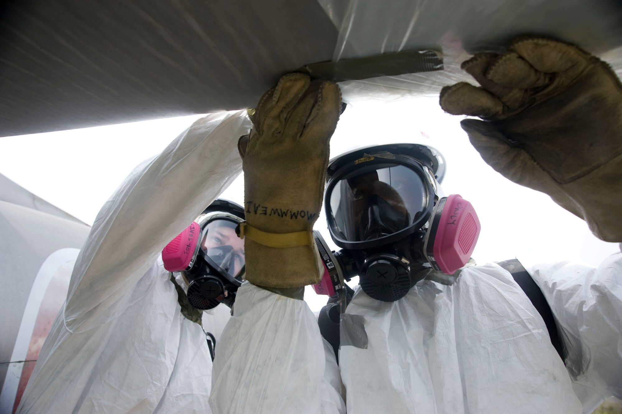 U.S Air Force Staff Sgt. Timothy Amburn and U.S Air Force Airman 1st Class Blake Cyrus, 35th Maintenance Squadron crash recovery team members, tape plastic wrap around part of an aircraft during an exercise at Misawa Air Base, Japan, Sept. 23, 2014. The plastic wrap is used to protect material during movement and handling. (U.S. Air Force photo by Staff Sgt. Alyssa C. Wallace)