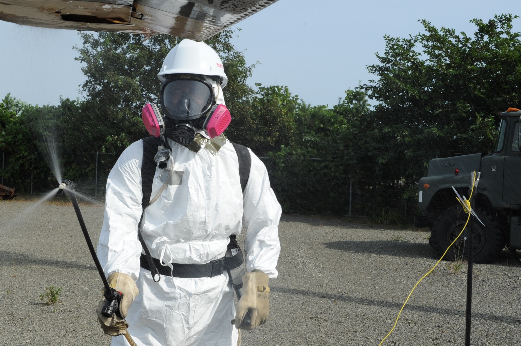 U.S Air Force Airman 1st Class Blake Cyrus, 35th Maintenance Squadron crash recovery team member, sprays an aircraft during a crash recovery exercise at Misawa Air Base, Japan, Sept. 23, 2014. The liquid simulated a chemical coating that would be sprayed across the aircraft to prevent composite material from becoming airborne. (U.S. Air Force photo by Airman Jordyn Rucker)
