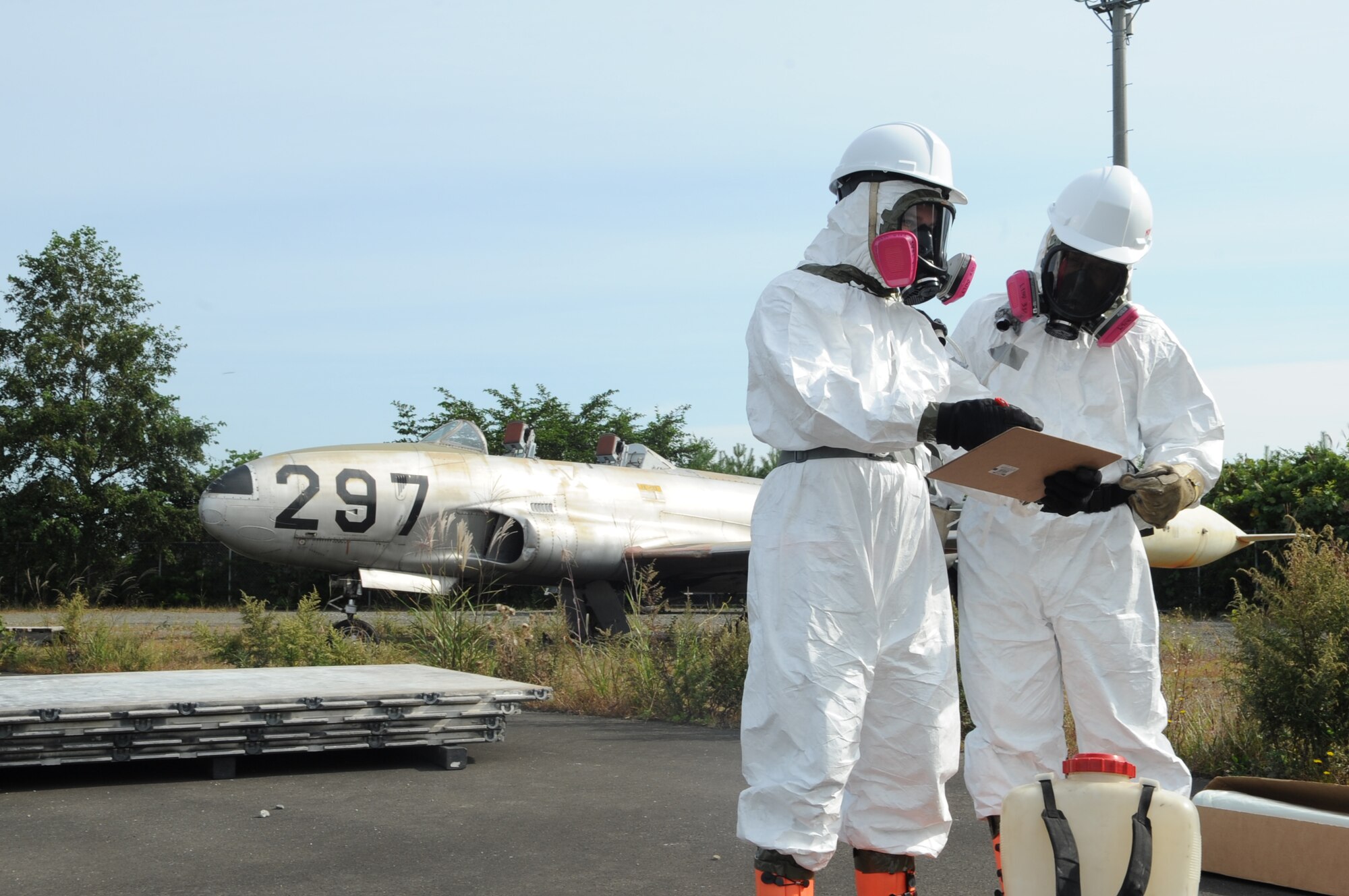 U.S Air Force Staff Sgt. Timothy Amburn and U.S Air Force Airman 1st Class Blake Cyrus, 35th Maintenance Squadron crash recovery team members, discuss their plan of action during a crash recovery exercise at Misawa Air Base, Japan, Sept. 23, 2014. The initial inspection determines how the aircraft lift will be executed based on its position and model. (U.S. Air Force photo by Airman Jordyn Rucker)