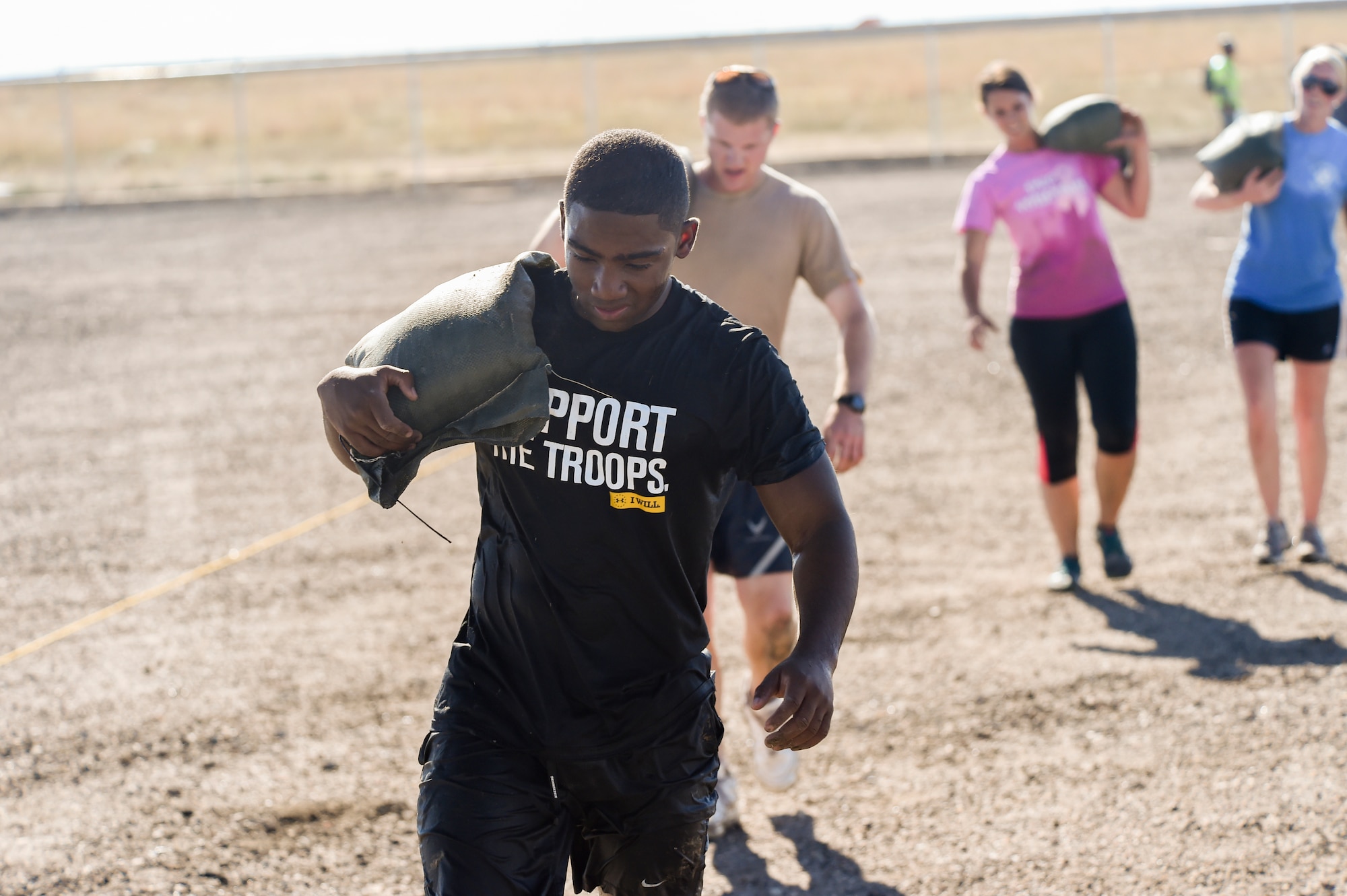 Team Buckley members carry sand bags as part of WARFIT Sept. 25, 2014, on Buckley Air Force Base, Colo. The 460th Civil Engineer Squadron hosted the September WARFIT, which consisted of a 5K run and a mud obstacle course. WARFIT is a way for the 460th Space Wing and base partner units to get together and stay physically fit. (U.S. Air Force photo by Senior Airman Phillip Houk/Released)