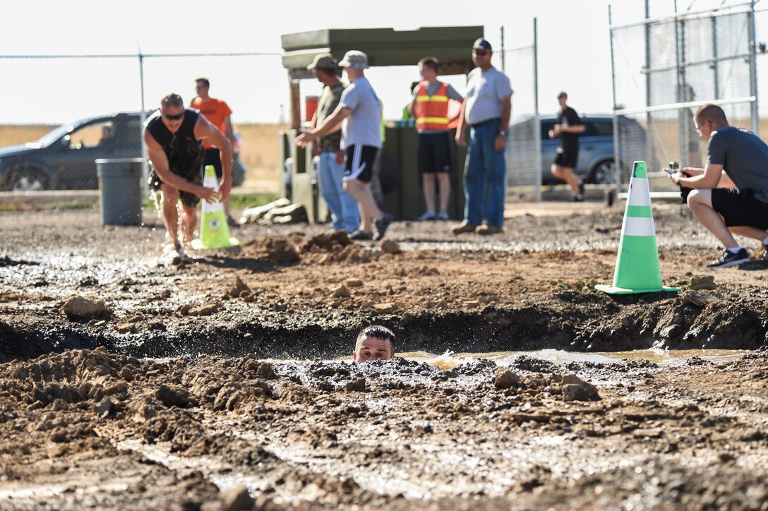 Col. John Wagner, 460th Space Wing commander, swims though a mud pit during WARFIT Sept. 25, 2014, on Buckley Air Force Base, Colo. The 460th Civil Engineer Squadron hosted the September WARFIT, which consisted of a 5K run and a mud obstacle course. WARFIT is a way for the 460th Space Wing and base partner units to get together and stay physically fit. (U.S. Air Force photo by Senior Airman Phillip Houk/Released)