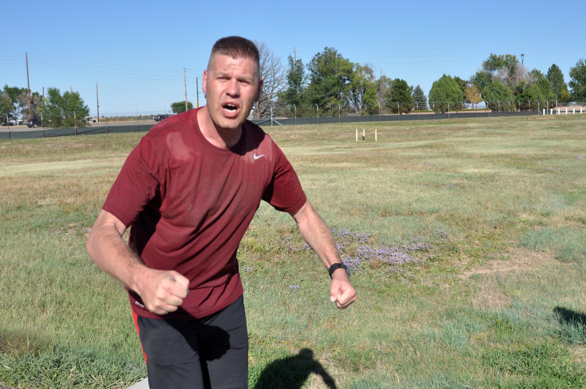 Team Buckley members celebrate as they finish WARFIT Sept. 25, 2014, on Buckley Air Force Base, Colo. The 460th Civil Engineer Squadron hosted the September WARFIT, which consisted of a 5K run and a mud obstacle course. WARFIT is a way for the 460th Space Wing and base partner units to get together and stay physically fit. (U.S. Air Force photo by Tech. Sgt. Robert Hazelett/Released)