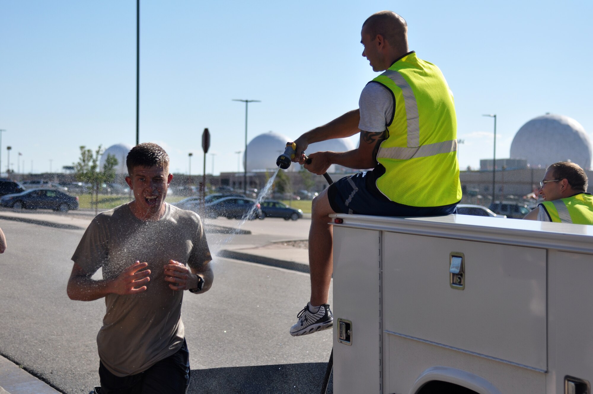 A Team Buckley member gets hosed off at the end of the WARFIT challenge Sept. 25, 2014, on Buckley Air Force Base, Colo. The 460th Civil Engineer Squadron hosted the September WARFIT, which consisted of a 5K run and a mud obstacle course. WARFIT is a way for the 460th Space Wing and base partner units to get together and stay physically fit. (U.S. Air Force photo by Tech. Sgt. Robert Hazelett/Released)