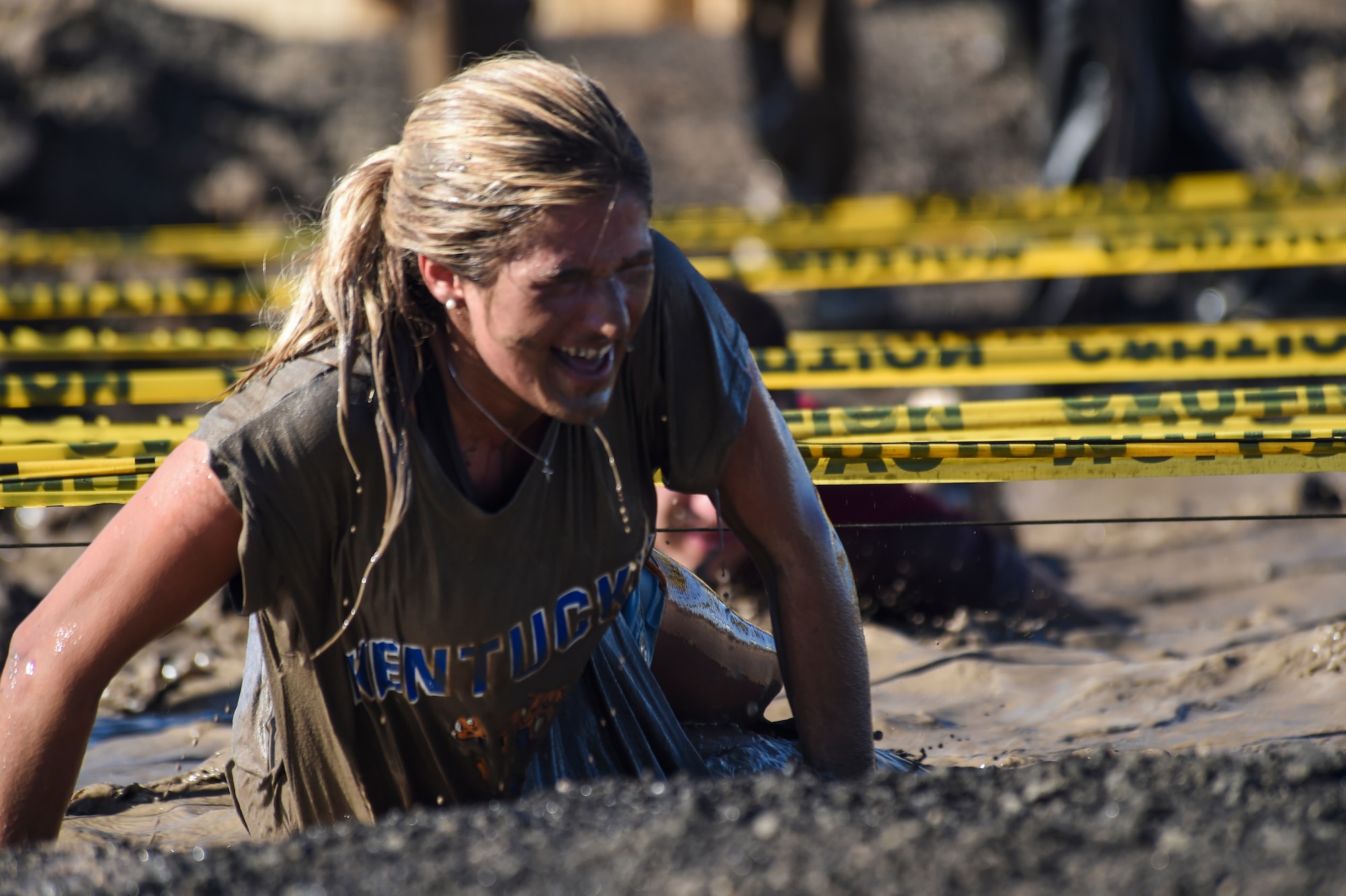 A Team Buckley member finishes the low-crawl obstacle during WARFIT Sept. 25, 2014, on Buckley Air Force Base, Colo. The 460th Civil Engineer Squadron hosted the September WARFIT, which consisted of a 5K run and a mud obstacle course. WARFIT is a way for the 460th Space Wing and base partner units to get together and stay physically fit. (U.S. Air Force photo by Senior Airman Phillip Houk/Released)