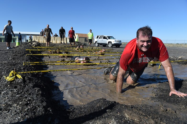 Chief Master Sgt. Brian Lavine finishes the low-crawl obstacle during WARFIT Sept. 25, 2014, on Buckley Air Force Base, Colo. The 460th Civil Engineer Squadron hosted the September WARFIT, which consisted of a 5K run and a mud obstacle course. WARFIT is a way for the 460th Space Wing and base partner units to get together and stay physically fit.  (U.S. Air Force photo by Airman Emily E. Amyotte/Released))