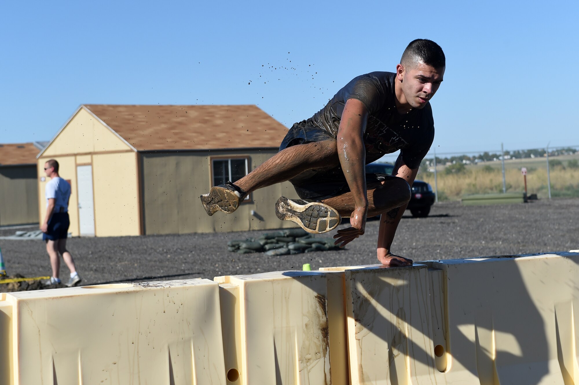 Senior Airman Jose Sanchez hurdles over an obstacle during WARFIT Sept. 25, 2014, on Buckley Air Force Base, Colo. The 460th Civil Engineer Squadron hosted the September WARFIT, which consisted of a 5K run and a mud obstacle course. WARFIT is a way for the 460th Space Wing and base partner units to get together and stay physically fit. (U.S. Air Force photo by Airman Emily E. Amyotte/Released)