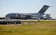 A C-17 Globemaster III from Elmendorf, Alaska, taxis next to an F-18 from Marine Fighter Attack Squadron 122 at Grand Forks Air Force Base, N.D. on Sept. 16, 2014. The C-17 helped transport members from the VMFA-122, who were on a return trip home to Marine Corps Air Station Beaufort, S.C. The Marines completed their tour in support of Operation Enduring Freedom. (U.S. Air Force photo/Staff Sgt. Luis Loza Gutierrez) 