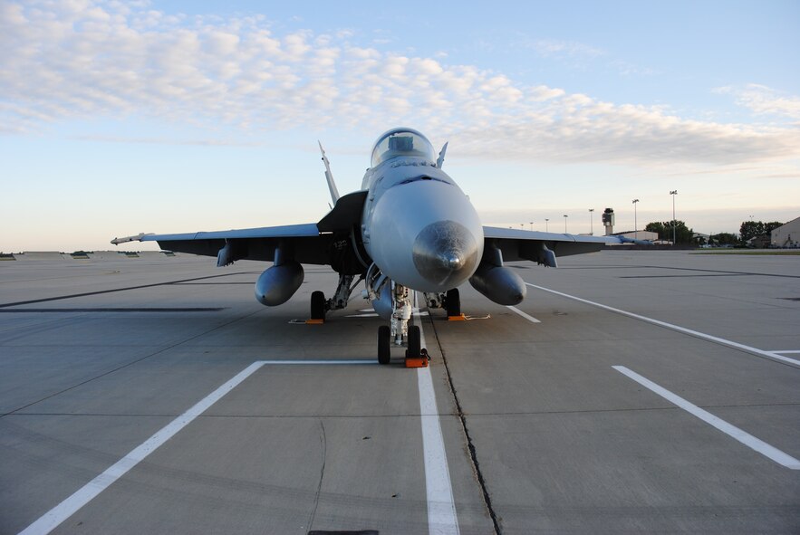 An F-18 Hornet from Marine Fighter Attack Squadron 122 sits on the flightline at Grand Forks Air Force Base, North Dakota. Sept.16, 2014. The aircraft was used in support of U.S. military operations in Afghanistan. Nearly a dozen of the Marine Corps pilots and aircraft made pit stops at Grand Forks AFB in order to rest and refuel while on their way to their home station of Marine Corps Air Station Beaufort, South Carolina. The F-18 Hornet is a twin-engine supersonic, all-weather carrier-capable multirole combat jet, designed as both a fighter and attack aircraft. (U.S. Air Force photo/Staff Sgt. Luis Loza Gutierrez) 

