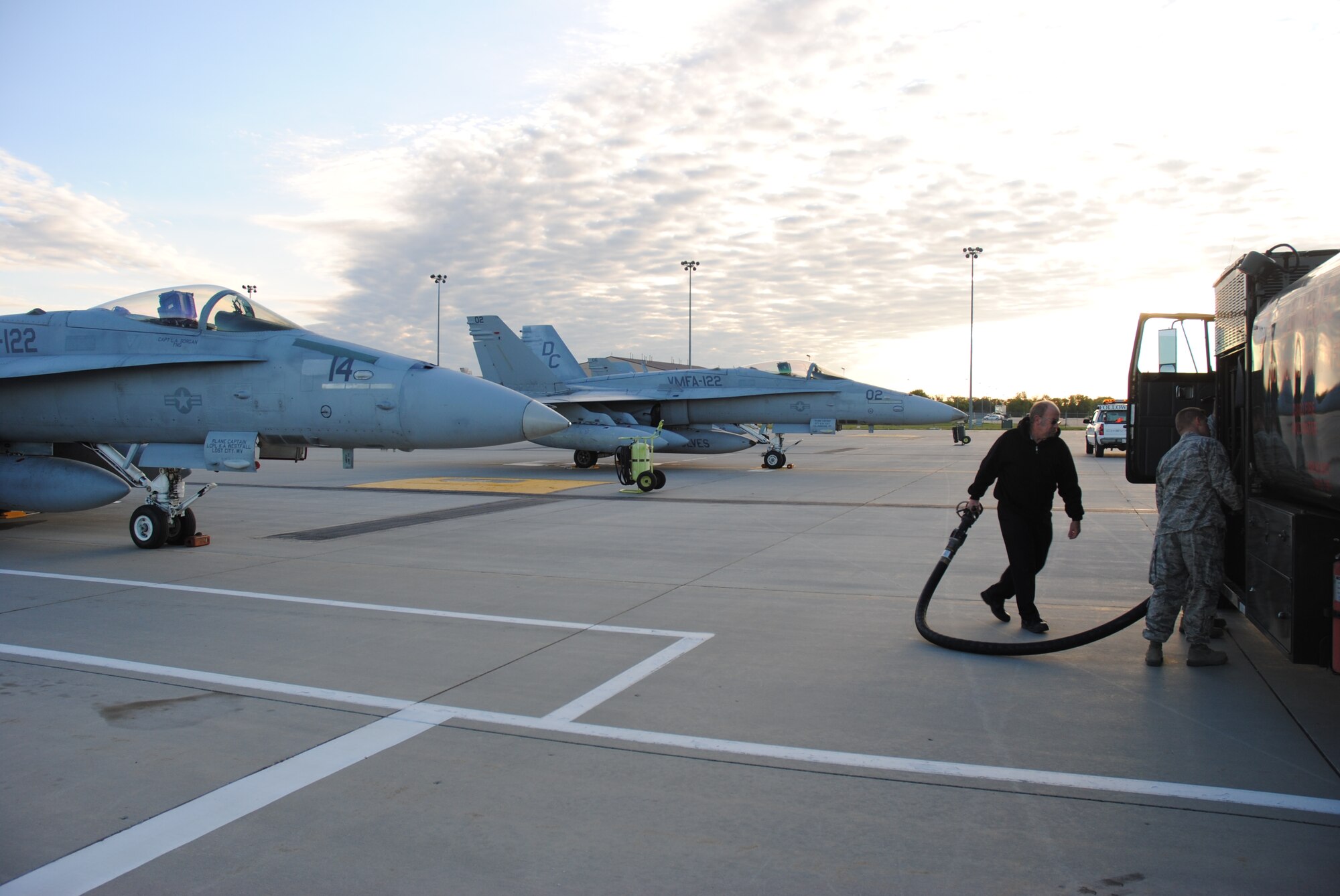 Transient Alert Air Craft servicer John Winter and Airmen from the 319th Logistics Readiness Squadron water and fuels flight prepare to pump jet fuel into an F-18 Hornet from Marine Fighter Attack Squadron 122 on Sept.  16, 2014, at Grand Forks Air Force Base, N.D.  Nearly a dozen of the Marine Corps pilots and aircraft made pit stops at Grand Forks AFB in order to rest and refuel. It took approximately 1,700 gallons to fill up each of the aircraft. (U.S. Air Force photo/Staff Sgt. Luis Loza Gutierrez) 