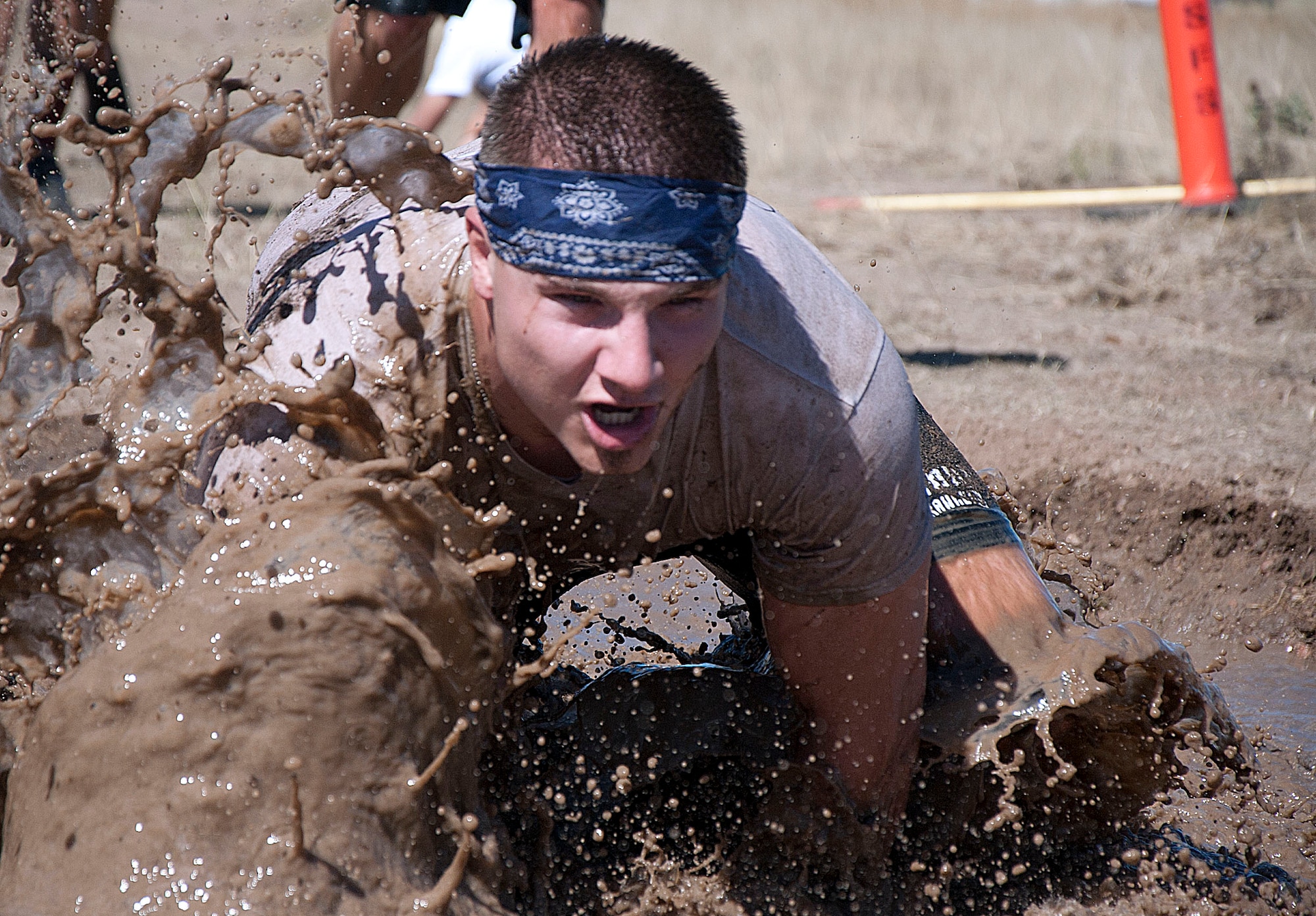 Airman 1st Class Daniel Davitt, 90th Medical Operations Squadron, splashes through a mud pit Sept. 27 as he competes to finish the Warren Top 3 Mud Run. Davitt competed as part of a team, the Spitting Llamas, which took 2nd place in the team category.  (U.S. Air Force photo by Airman 1st Class Brandon Valle) 
