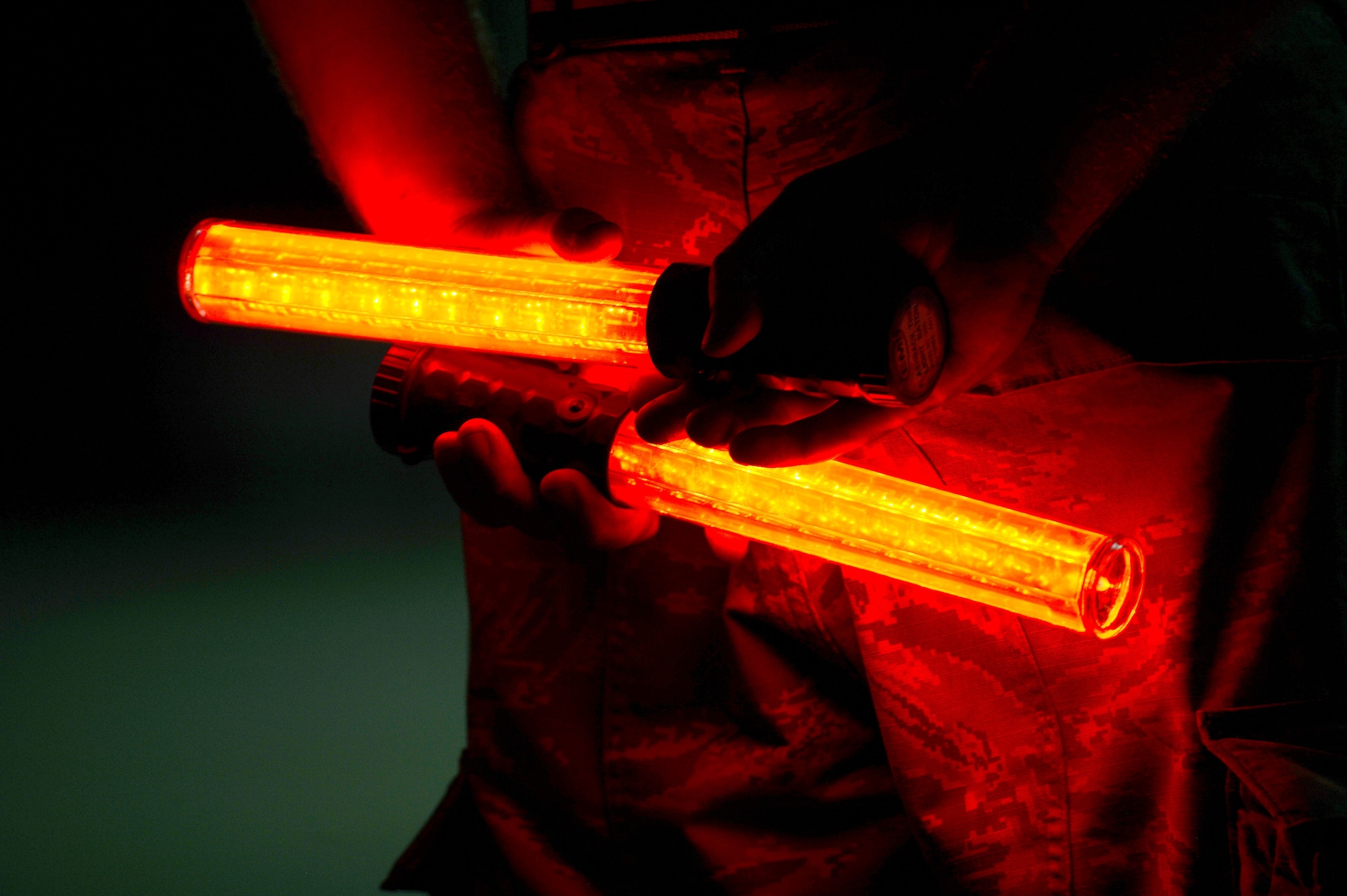 A U.S. Air Force dedicated crew chief, holds marshaling wands in preparation to launch an F-16CM Fighting Falcon during night operations at Shaw Air Force Base, S.C., Sept. 18, 2014. Marshalling wands are used to direct pilots during low visibility environments by using a series of hand signals. (U.S. Air Force photo by Airman 1st Class Jensen Stidham/Released)