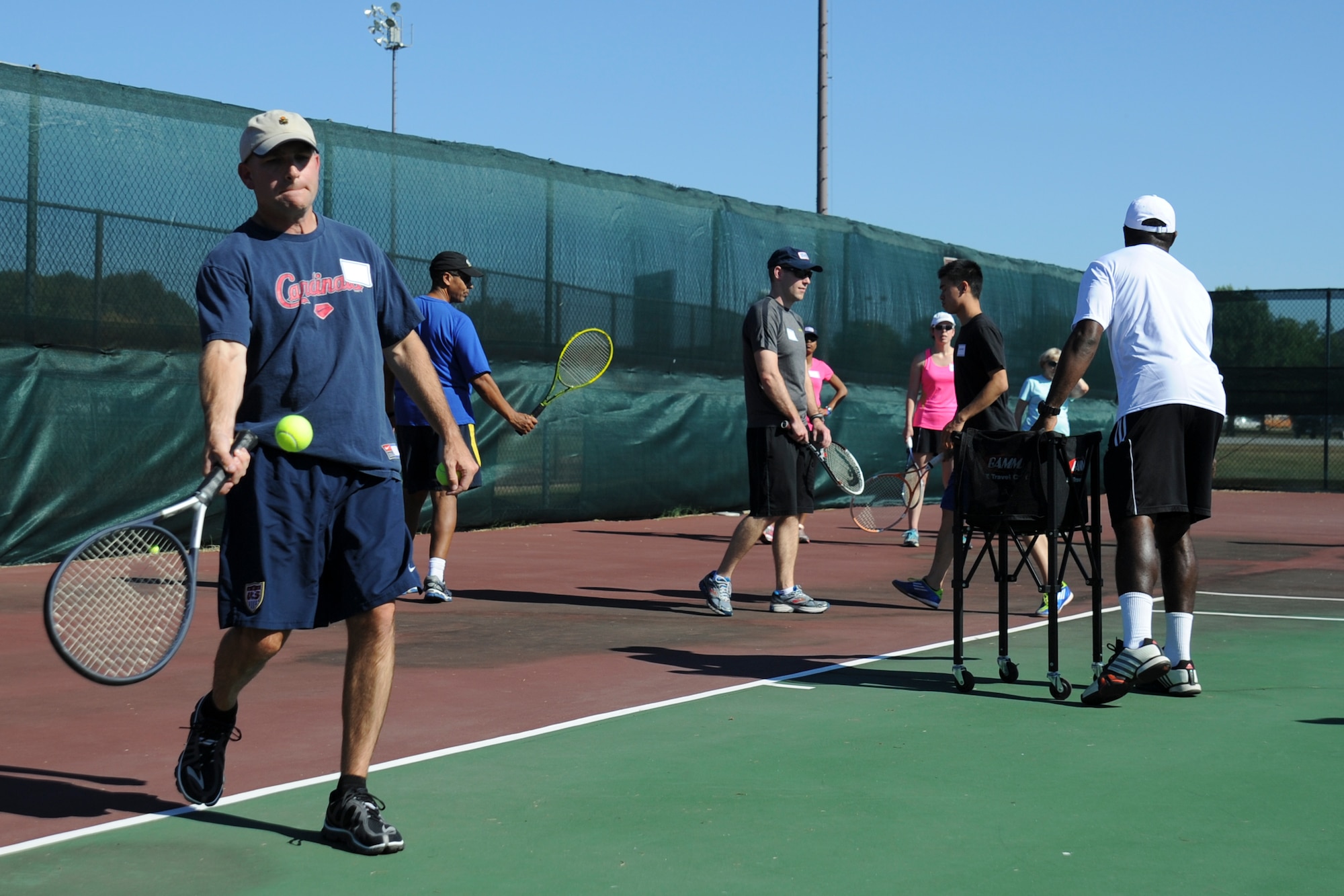 Thanking the Troops through Tennis attendees practice their forehand at the West Fitness Center, Sept. 30, 2014. The clinic taught tennis fundamentals to Joint Base Andrews families. (U.S. Air Force photo by Airman 1st Class J.D. Maidens/ released)